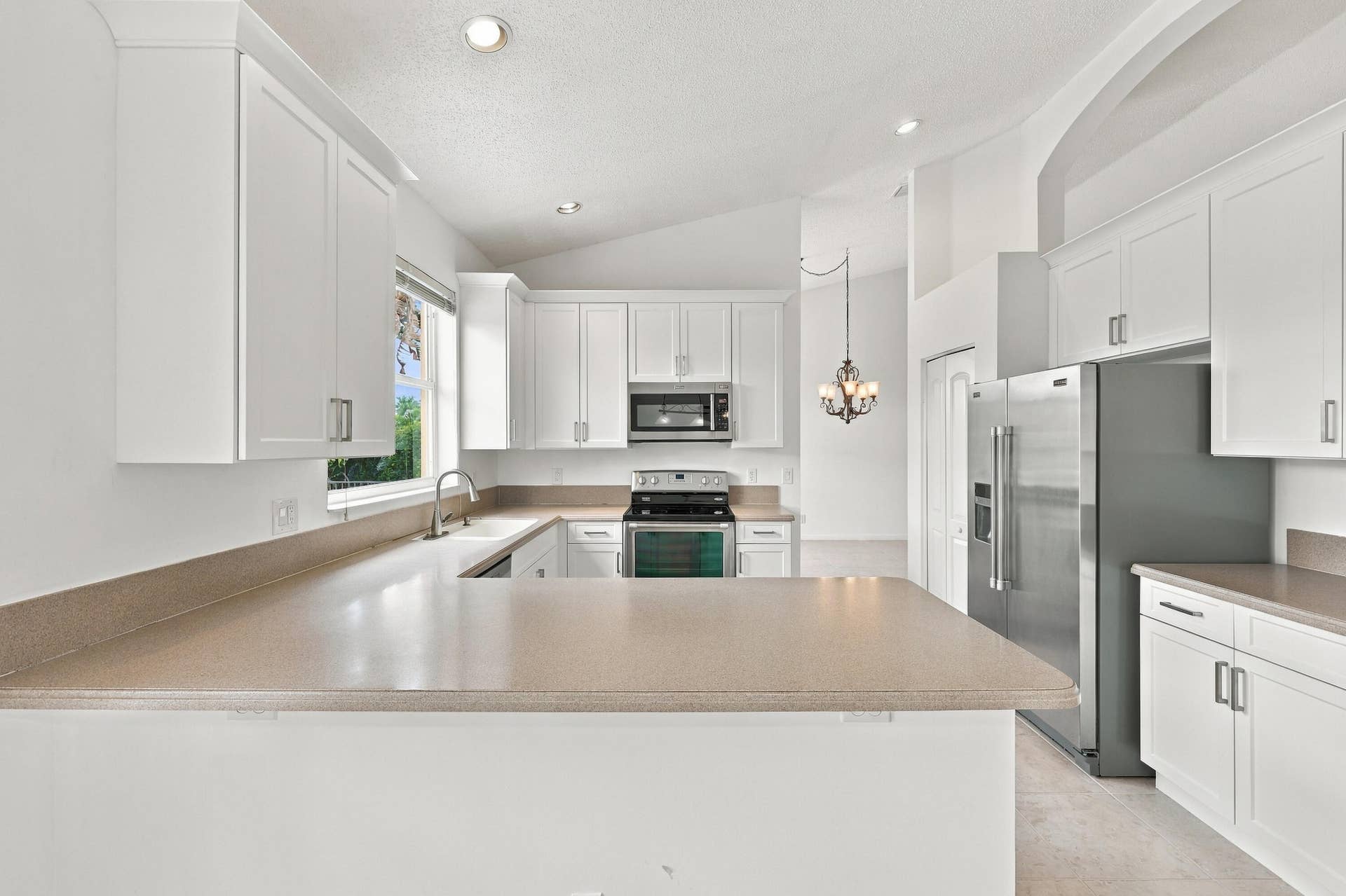10671 St Thomas Drive, Boca Raton, FL 33498 Generous countertop space, abundant cabinetry, and a practical U-shaped layout make this kitchen ideal for meal preparation, entertaining, and everyday living.