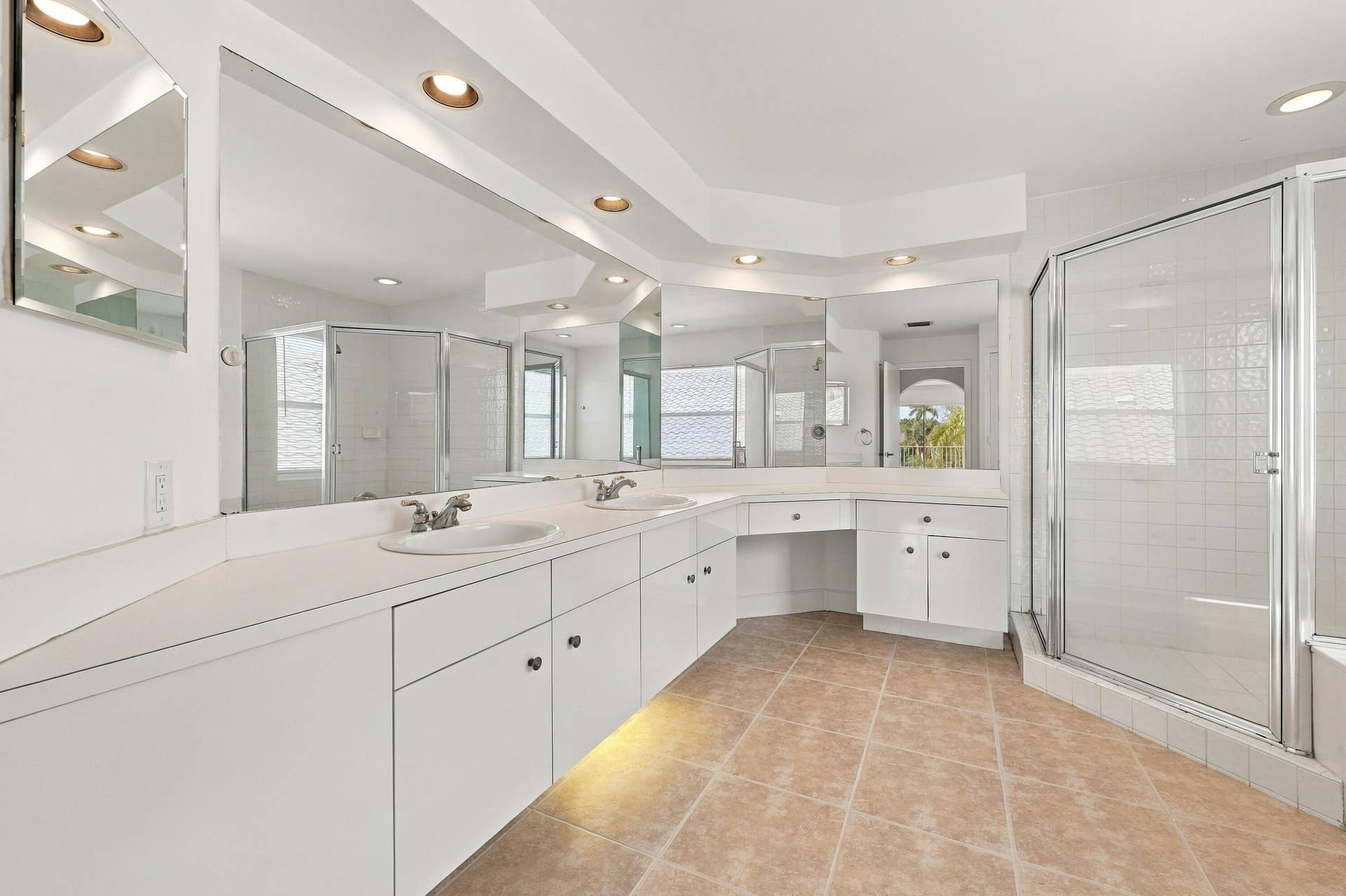 10671 St Thomas Drive, Boca Raton, FL 33498 Generous counter space, dual sinks, extensive cabinetry, and a separate makeup vanity make this primary bathroom both functional and inviting.