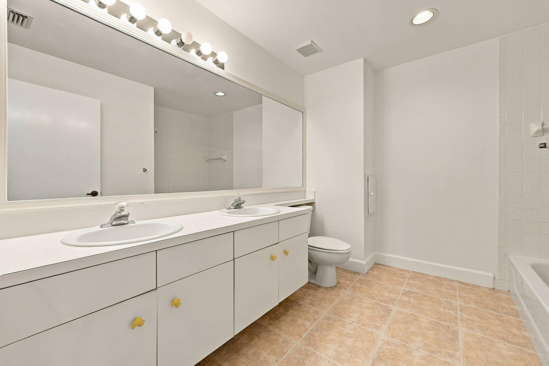 10671 St Thomas Drive, Boca Raton, FL 33498 This well-appointed upstairs bathroom features an expansive dual-sink vanity, generous counter space, abundant cabinetry, and a large mirror with overhead lighting.