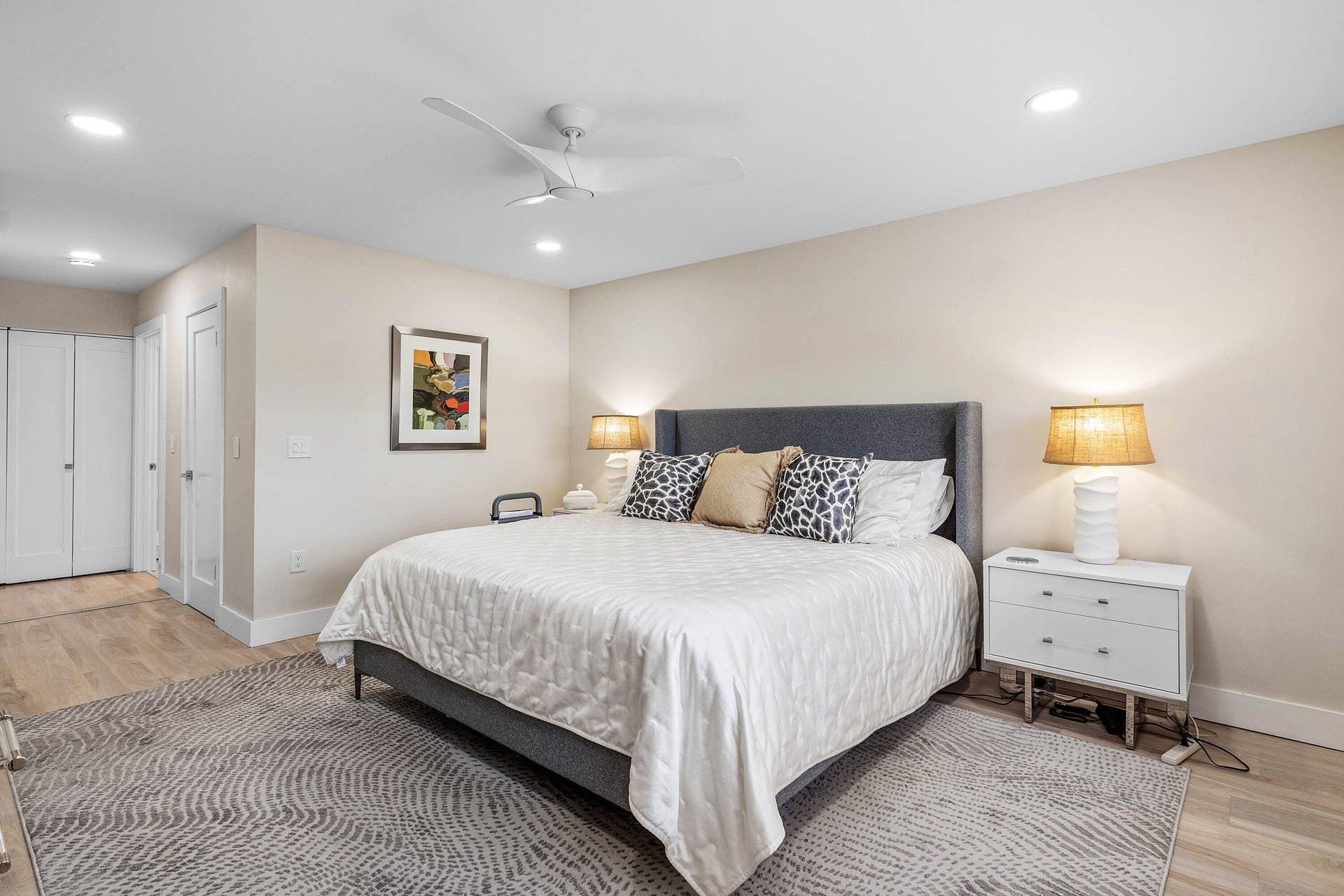 Neutral-toned interior featuring wood-finish flooring, recessed lighting, and a modern three-blade ceiling fan