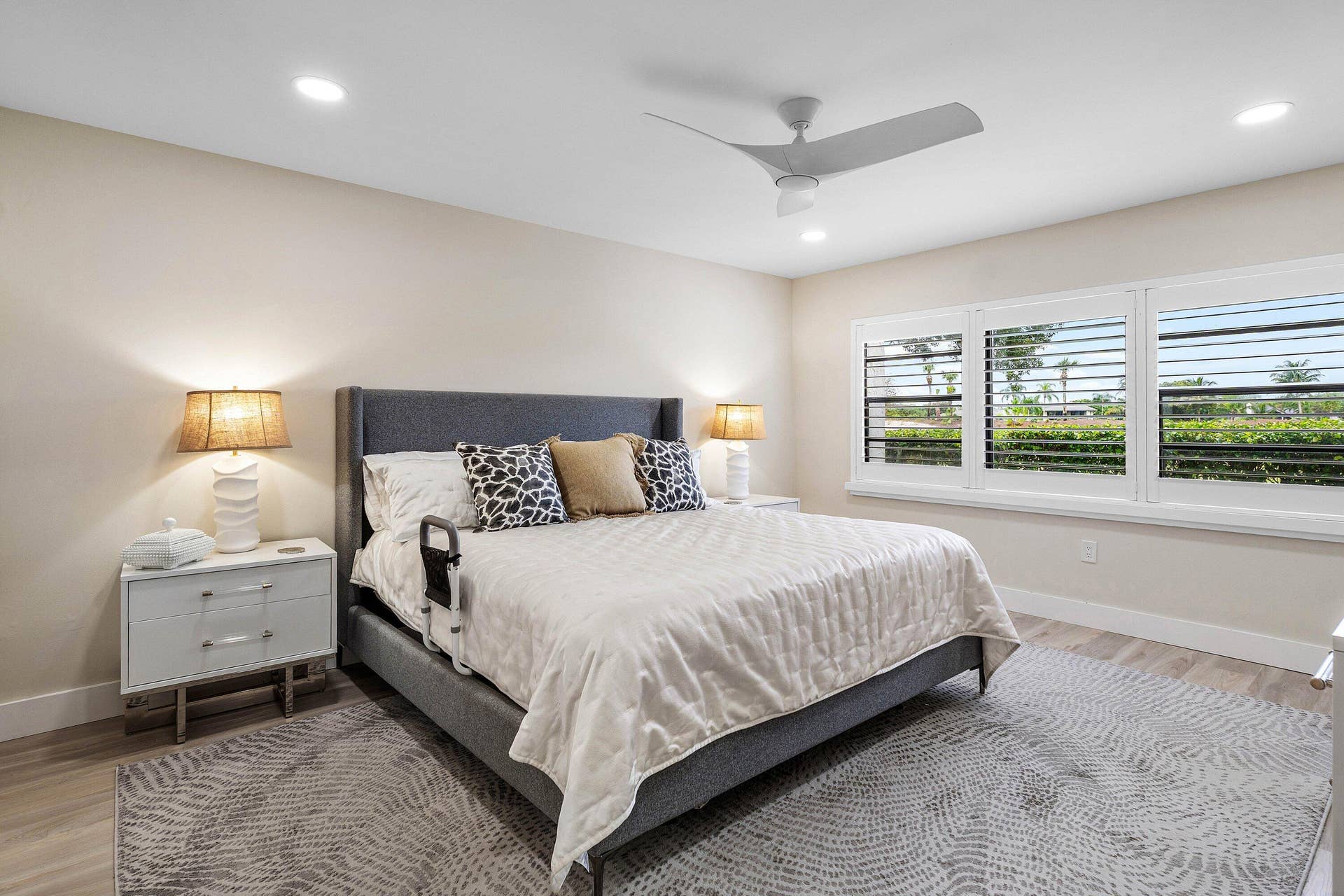Neutral-toned walls, recessed lighting, modern ceiling fan, wood-finish flooring, and white plantation shutters