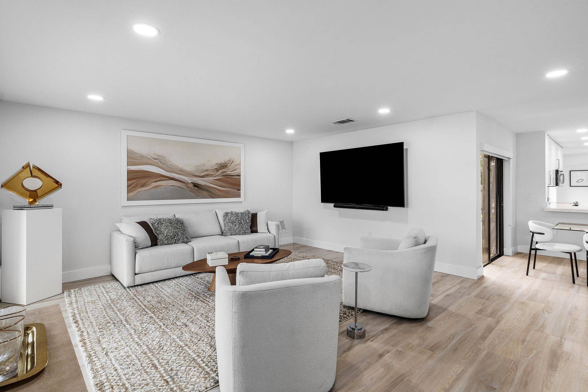 Open-concept living space featuring wood-finish flooring, recessed lighting, and wall-mounted television hardware