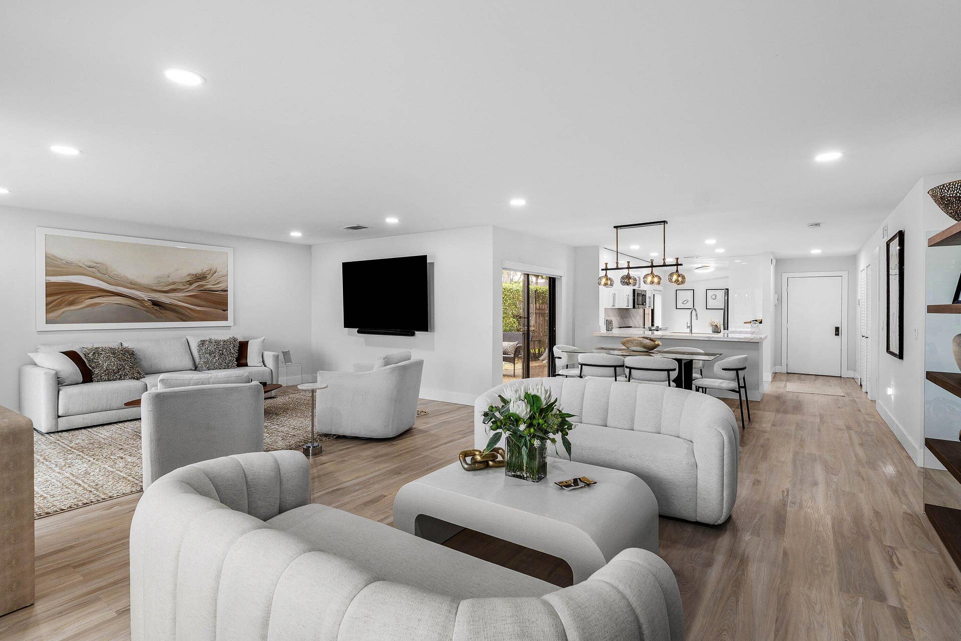 Open floor plan featuring wood-finish flooring, recessed lighting, and a multi-pendant island light fixture