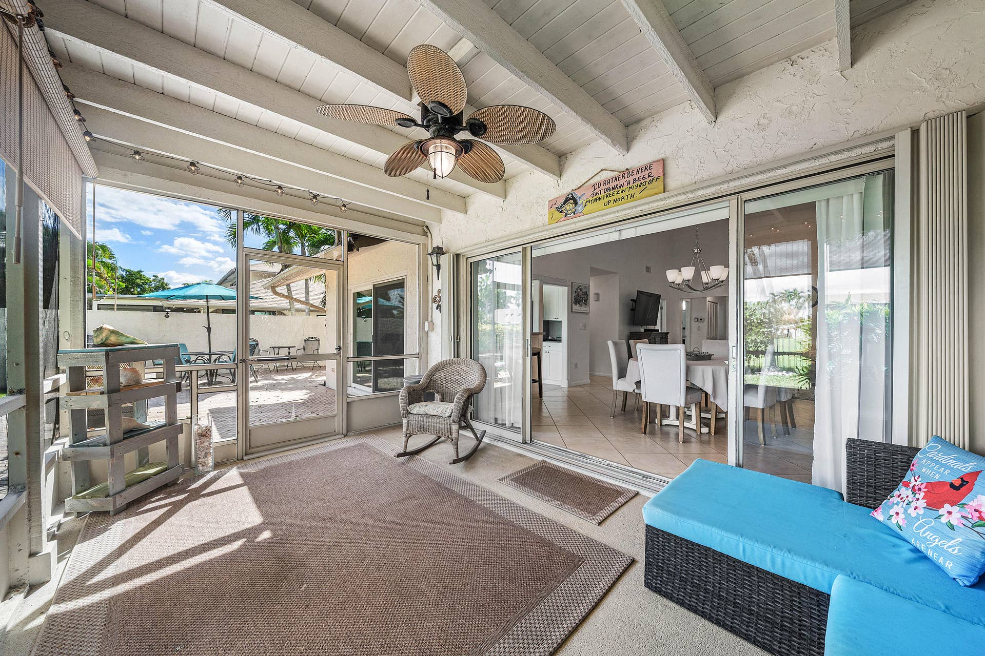 503 SW 29TH Avenue, Delray Beach, FL 33445 Screened-in patio featuring an exposed beam ceiling, ceiling fan with integrated lighting, and glass sliding doors