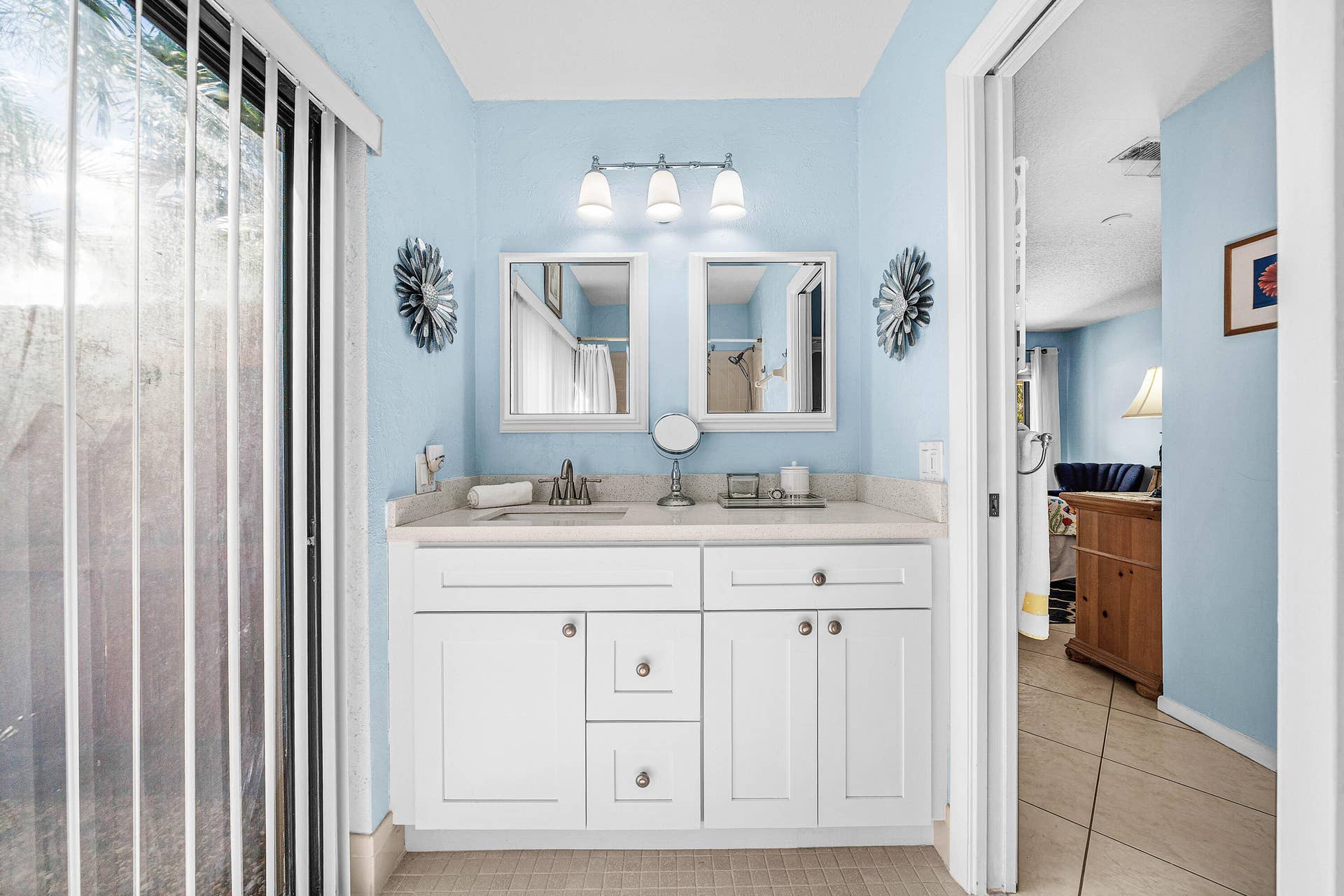 503 SW 29TH Avenue, Delray Beach, FL 33445 Bathroom vanity featuring white cabinetry, a neutral stone-look countertop, dual square-framed mirrors, and a three-light fixture