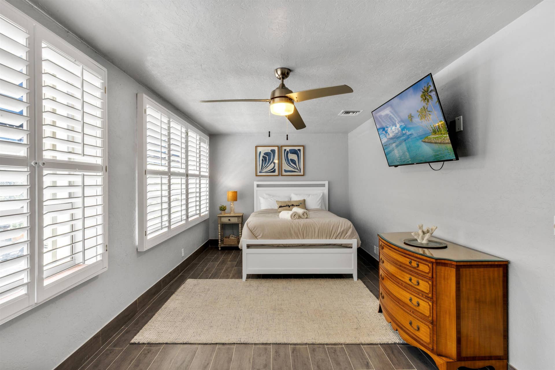 419 E Atlantic Avenue, Delray Beach, FL 33483 Wood-finish flooring, plantation shutters, and a central ceiling fan with integrated lighting