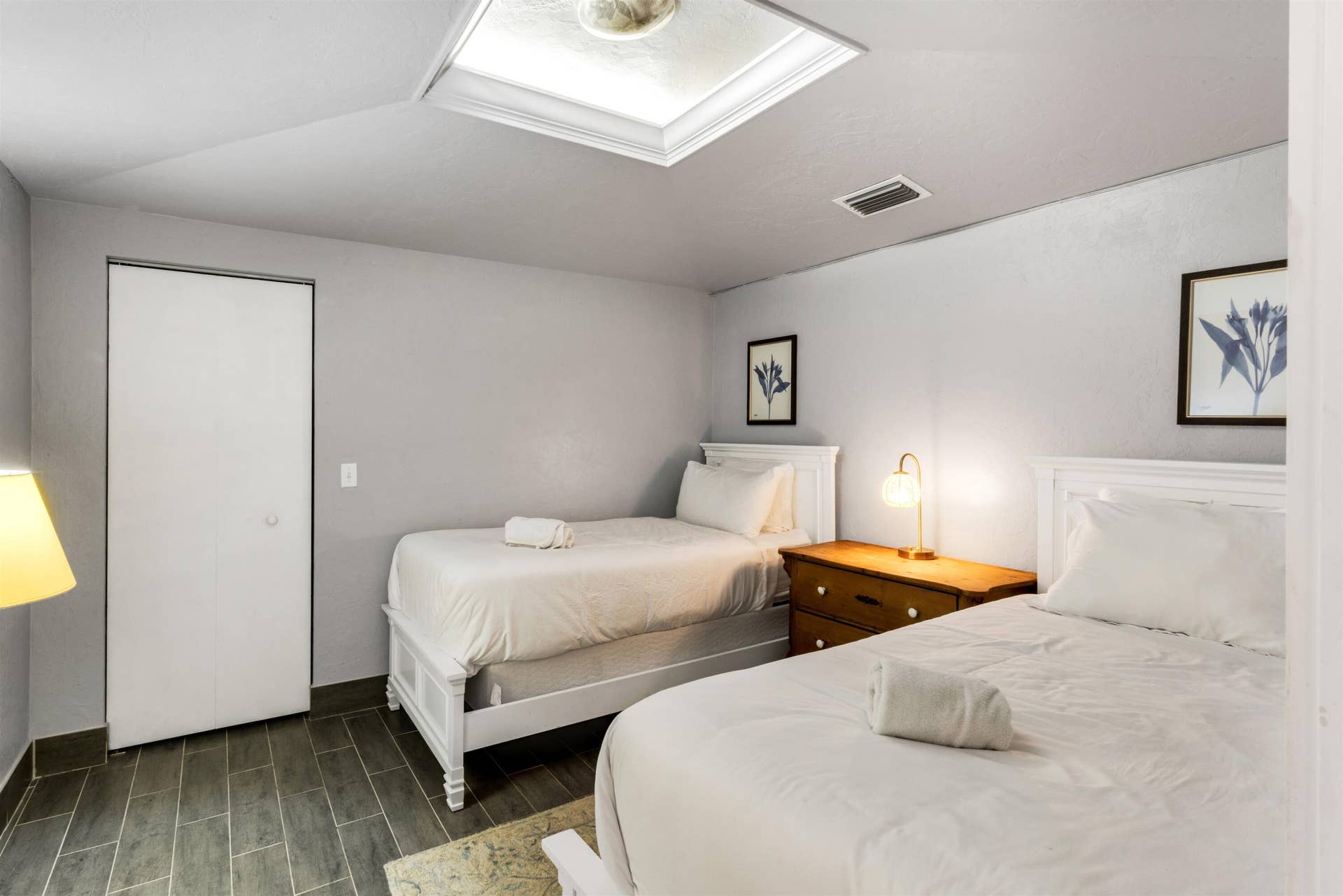 419 E Atlantic Avenue, Delray Beach, FL 33483 Room featuring a rectangular skylight, wood-finish flooring, and a floor-to-ceiling closet with a white panel door