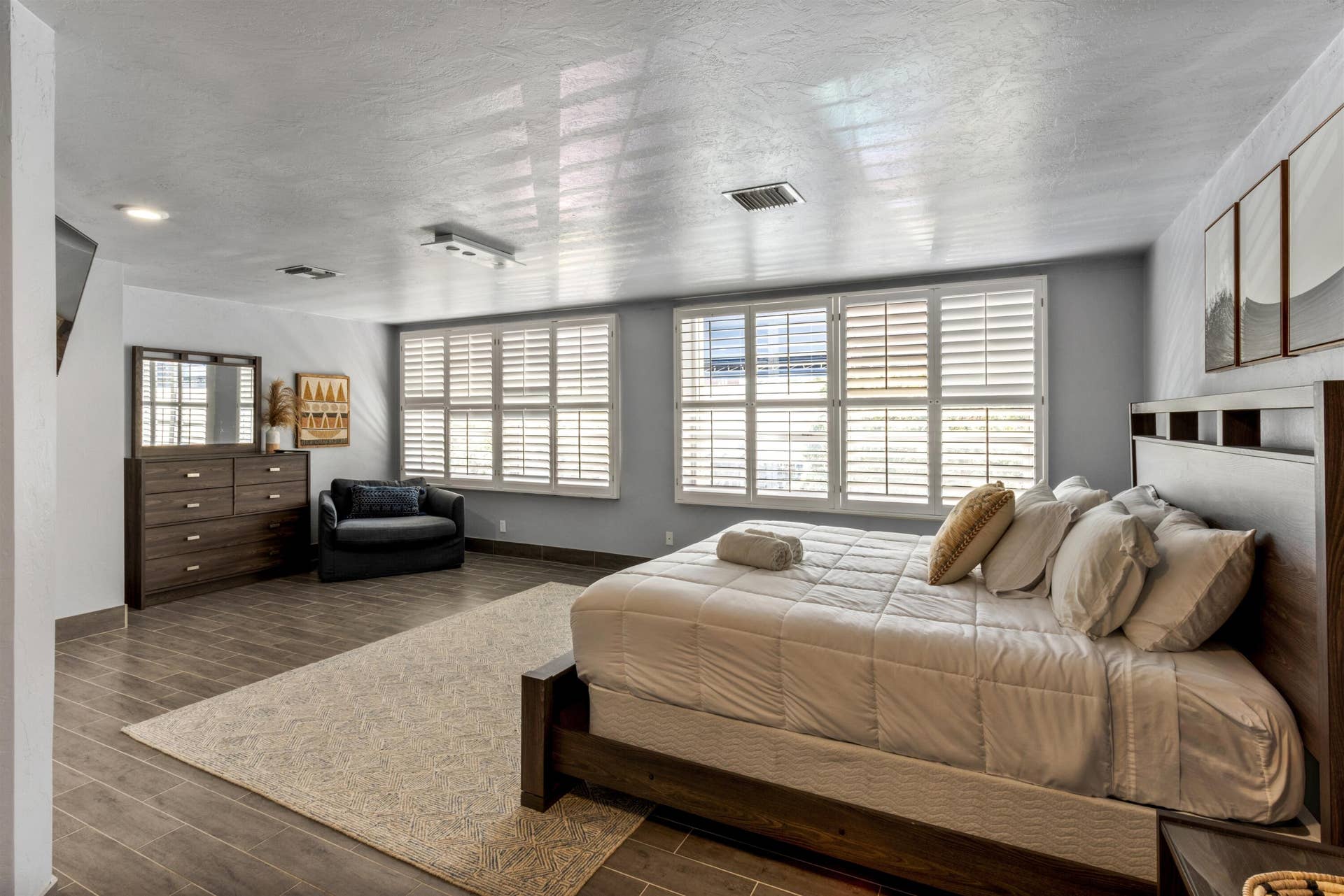 419 E Atlantic Avenue, Delray Beach, FL 33483 Spacious room featuring wood-finish flooring, dual windows with plantation shutters, recessed lighting, and a neutral color palette
