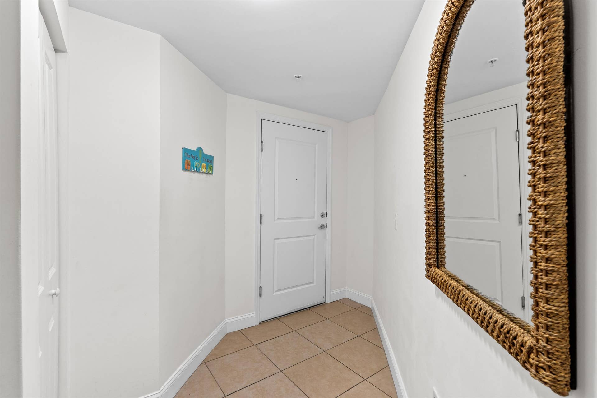 Entry featuring ceramic tile flooring, neutral wall paint, and a six-panel door with metallic hardware