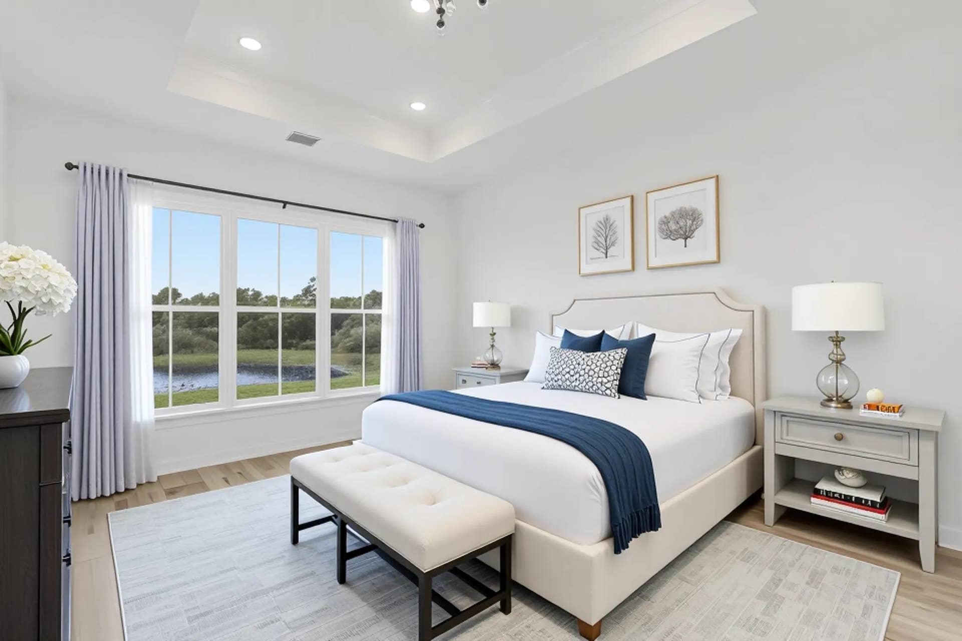 Tray ceiling featuring recessed lighting, large multi-pane windows with exterior water scenery, and wood like flooring
