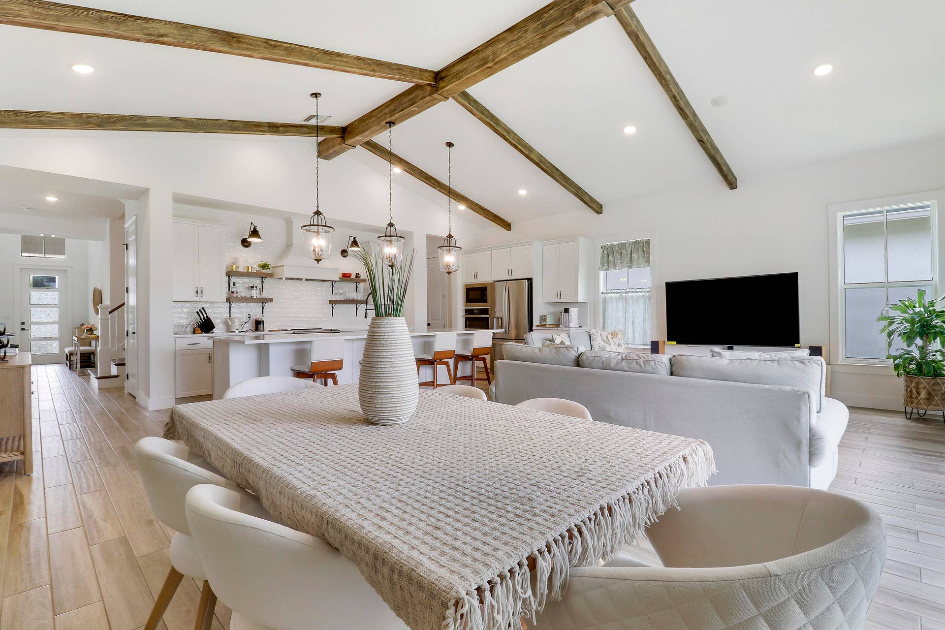 Vaulted ceiling featuring exposed wood like beams, wood like flooring, recessed lighting, and kitchen island with pendant fixtures