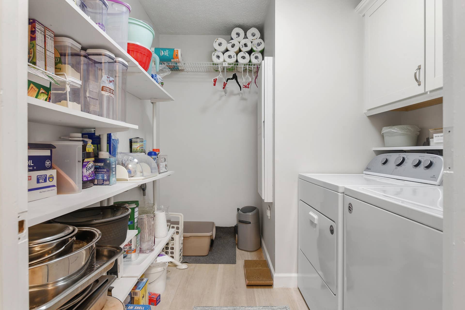 3098 SE BUR Street, Port St Lucie, FL 34952 Convenient indoor laundry room featuring a washer and dryer, extensive built-in shelving, and additional cabinetry for organized storage.