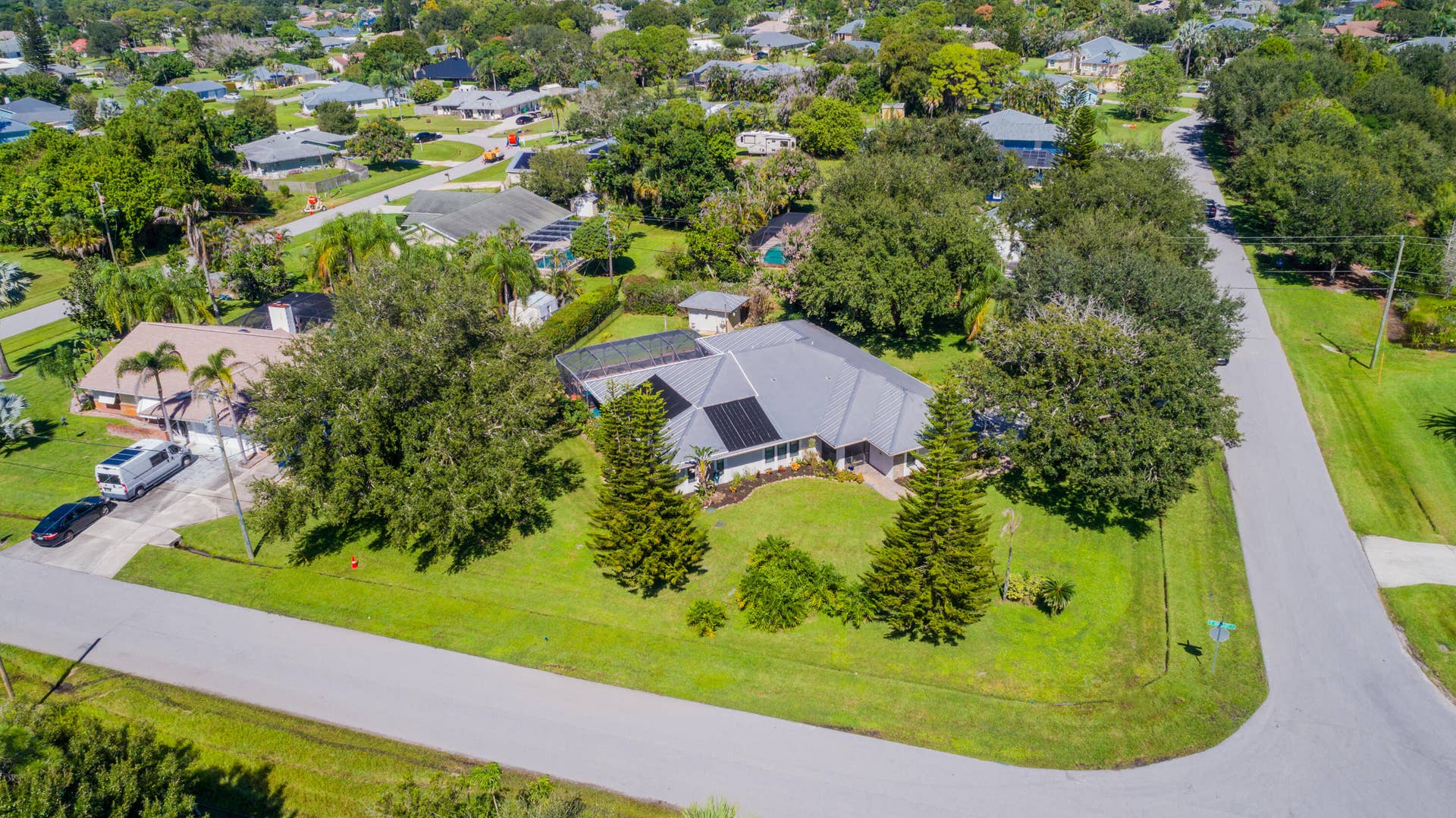 3098 SE BUR Street, Port St Lucie, FL 34952 Expansive lawn area featuring mature trees, established landscaping