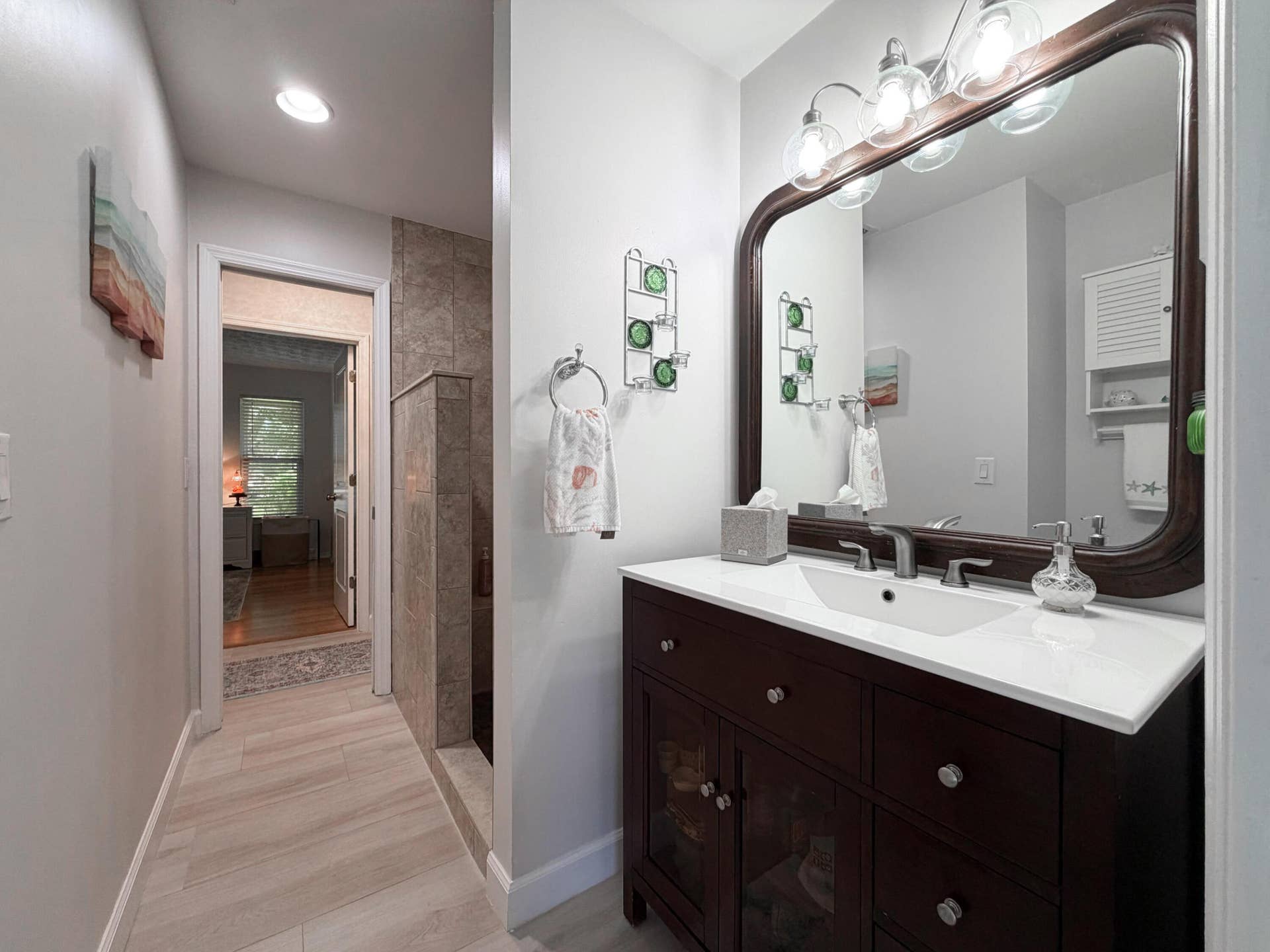3098 SE BUR Street, Port St Lucie, FL 34952 Featuring a rich wood vanity, modern lighting, and a tiled walk-in shower.