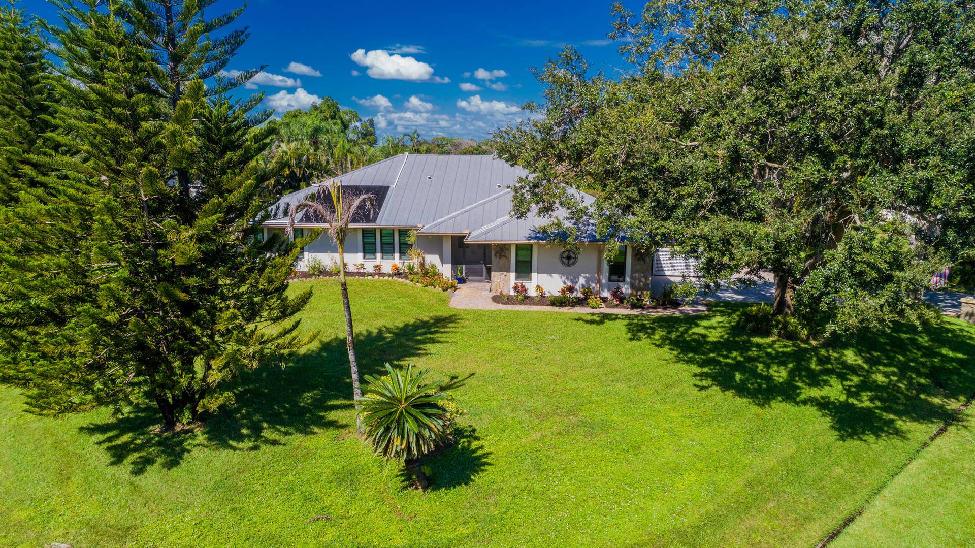 3098 SE BUR Street, Port St Lucie, FL 34952 Beautiful curb appeal on a .49-acre corner lot! This home features impact-resistant windows, a metal roof, and mature shade trees, combining style, comfort, and added storm protection.