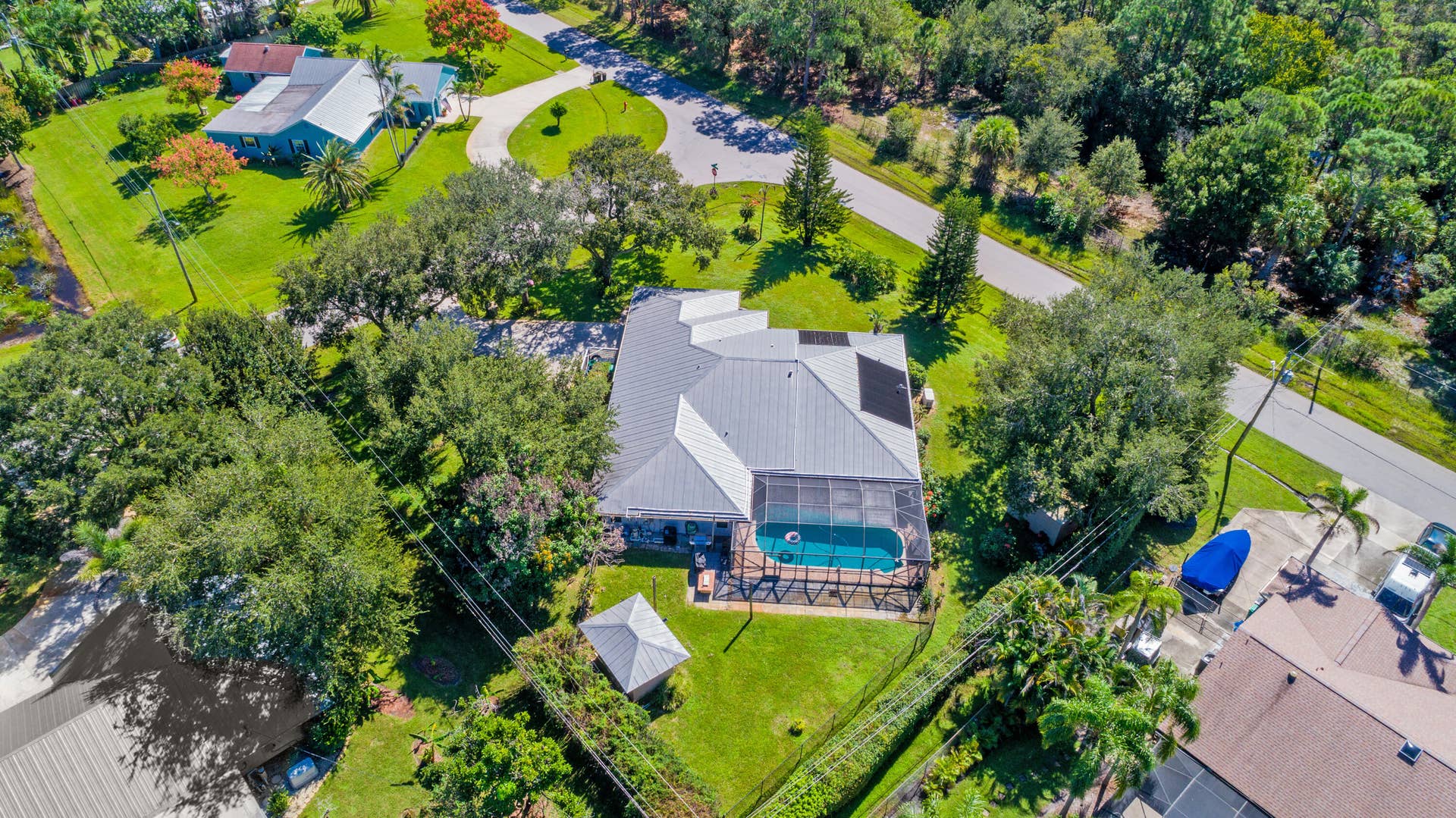 3098 SE BUR Street, Port St Lucie, FL 34952 This aerial view captures the impressive size of this .49-acre corner property, featuring a screened pool, mature shade trees, fully fenced backyard, and plenty of room to enjoy the outdoors. No HOA!