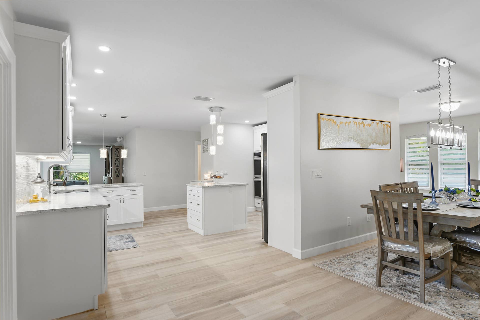 3098 SE BUR Street, Port St Lucie, FL 34952 Freshly painted interiors, updated lighting, and beautiful flooring create a bright, modern feel throughout the open kitchen and dining area.