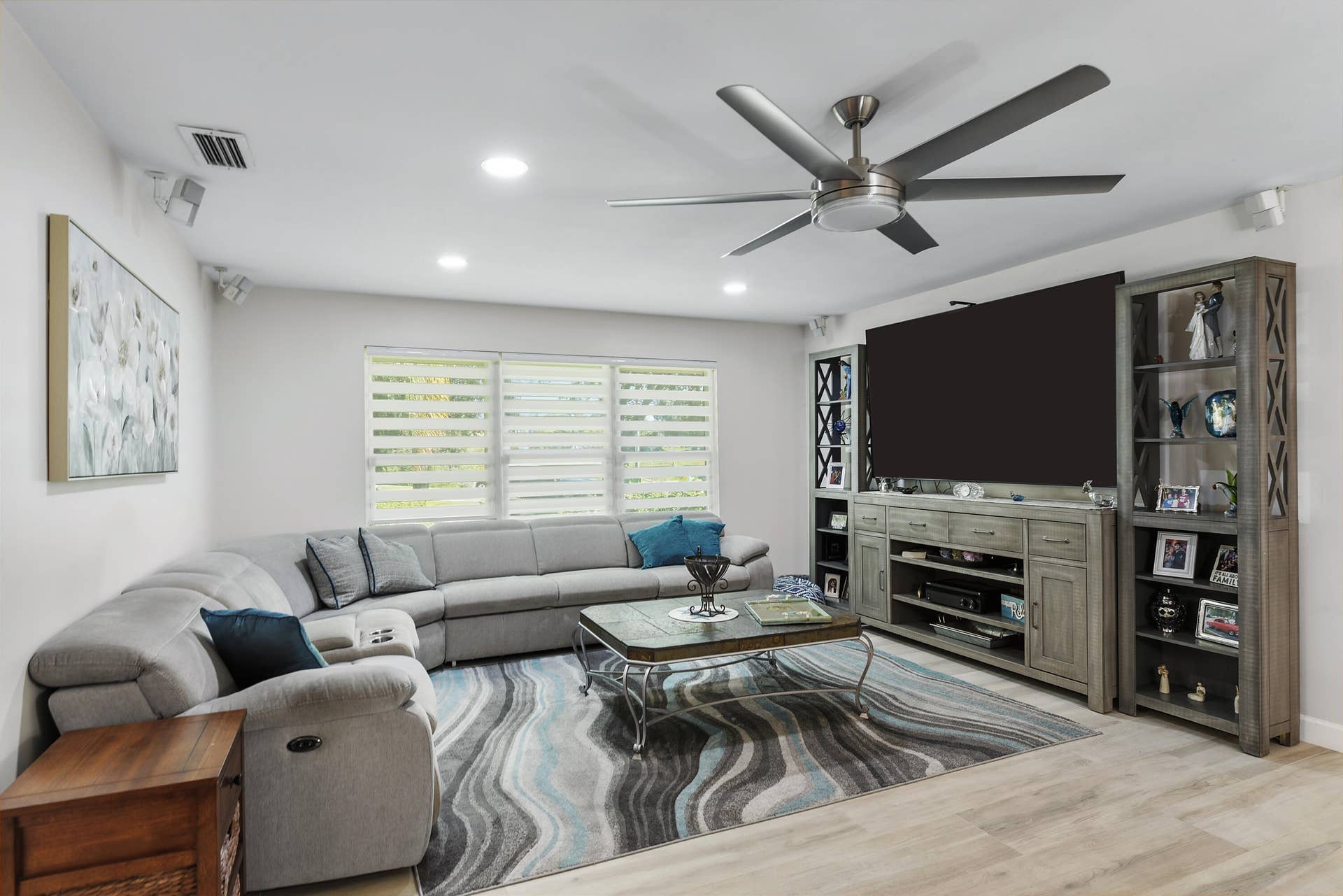 3098 SE BUR Street, Port St Lucie, FL 34952 A fantastic family room featuring beautiful wide-plank flooring, a large entertainment center, stylish ceiling fan, and abundant natural light. Plenty of space for movie nights, relaxing, and gathering with family and friends!