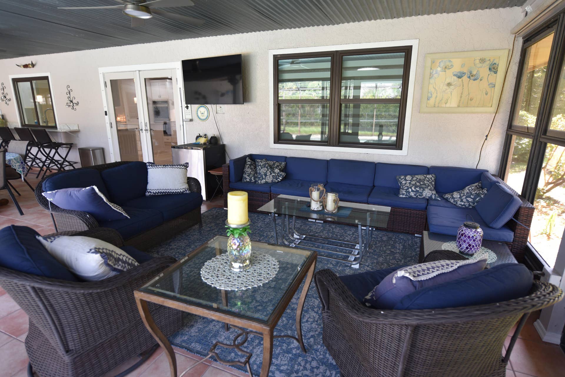 3098 SE BUR Street, Port St Lucie, FL 34952 An inviting covered lanai designed for relaxation and entertaining, complete with comfortable seating and an outdoor TV. Perfect for enjoying the Florida lifestyle!