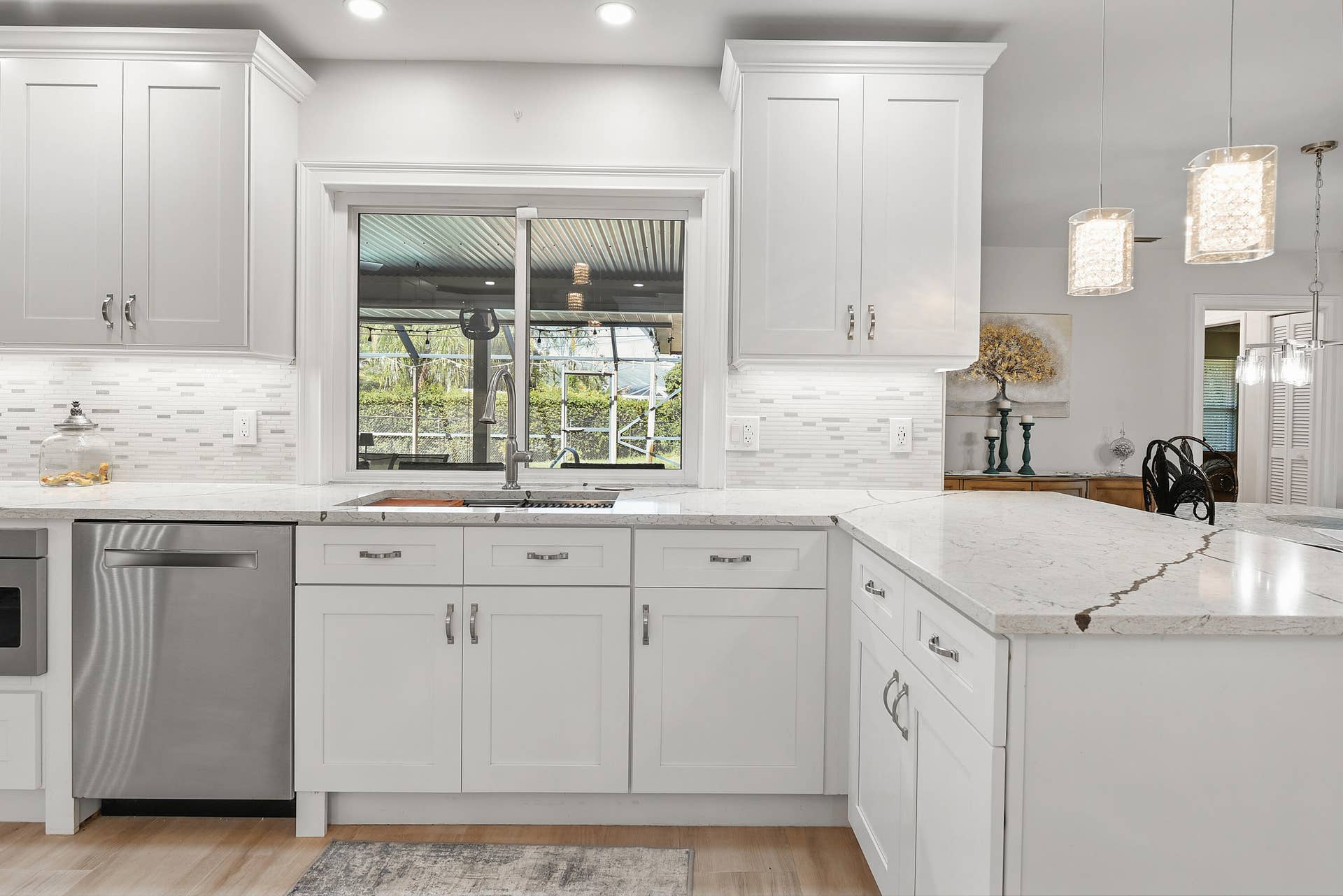 3098 SE BUR Street, Port St Lucie, FL 34952 Beautiful decorative mosaic tile backsplash complements the marble-look countertops and crisp white cabinetry. The double-basin stainless steel sink with high-arc faucet adds both style and functionality to this gorgeous kitchen!