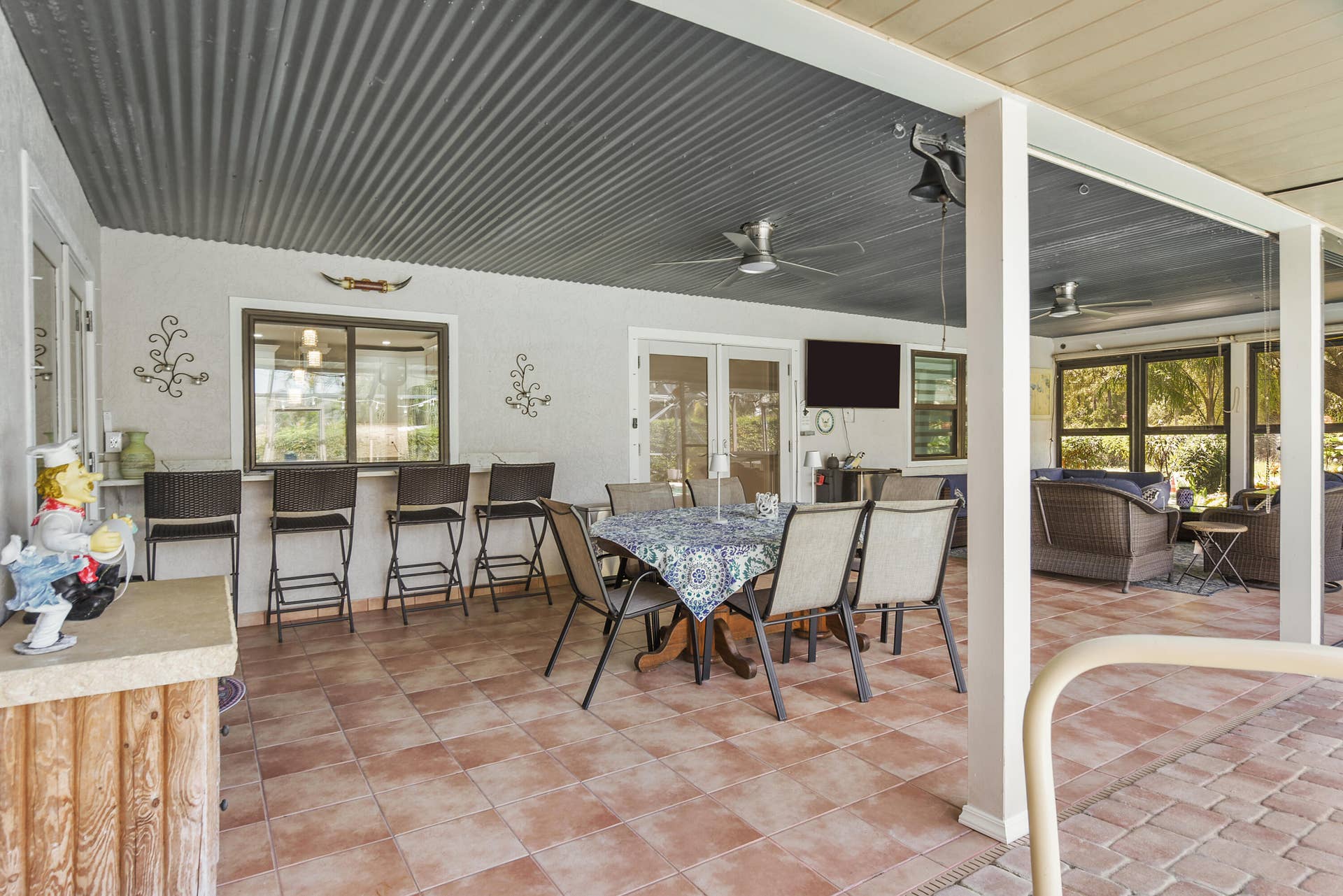 3098 SE BUR Street, Port St Lucie, FL 34952 An entertainer's delight! This impressive covered lanai offers a dining area, breakfast bar, outdoor TV, and comfortable lounging space overlooking the pool. Perfect for gatherings or quiet afternoons!