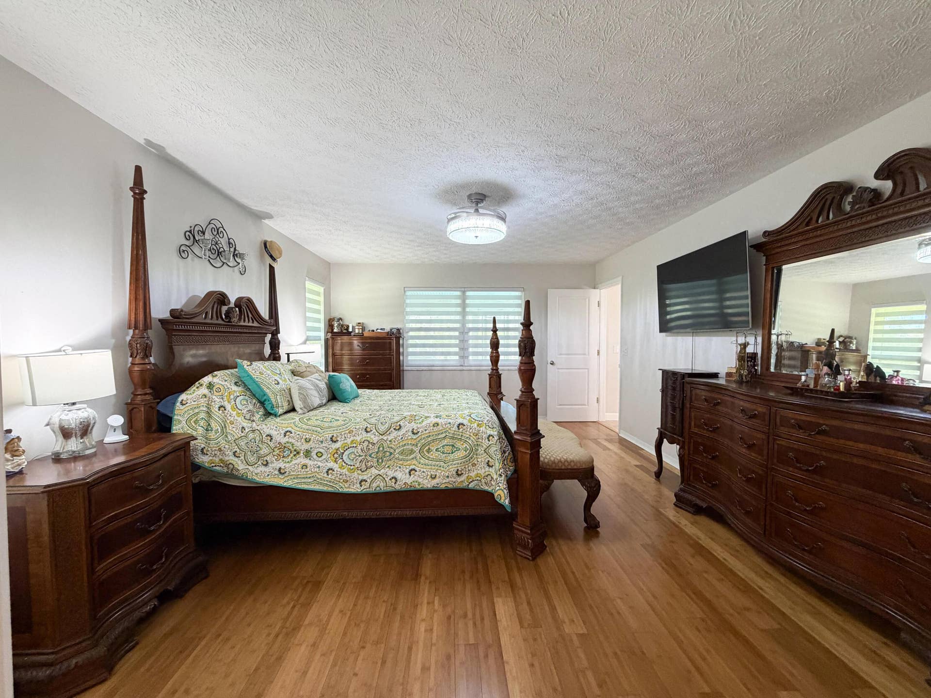 3098 SE BUR Street, Port St Lucie, FL 34952 Generously sized primary bedroom featuring beautiful bamboo flooring, stylish window treatments, and plenty of room for oversized furniture.