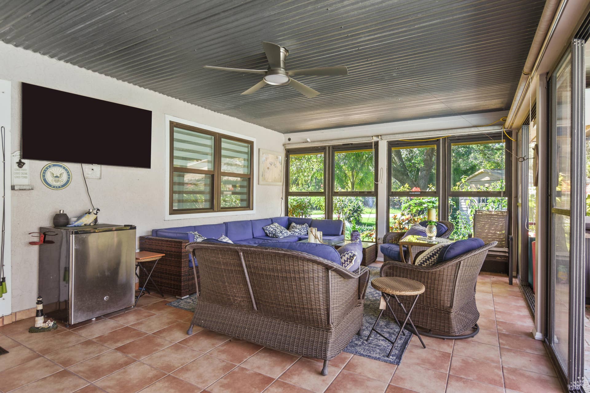 3098 SE BUR Street, Port St Lucie, FL 34952 Enjoy year-round outdoor living in this expansive covered lanai, featuring screened enclosures, sliding glass panels, and dedicated dining and lounging areas overlooking the pool. Perfect for entertaining!