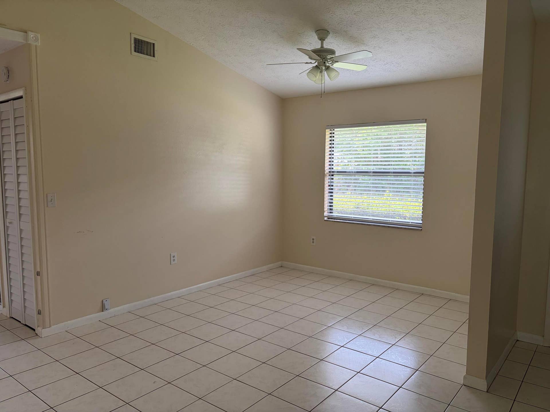 Vaulted ceiling with a white overhead fan, neutral wall finishes, ceramic tile flooring, and horizontal window blinds
