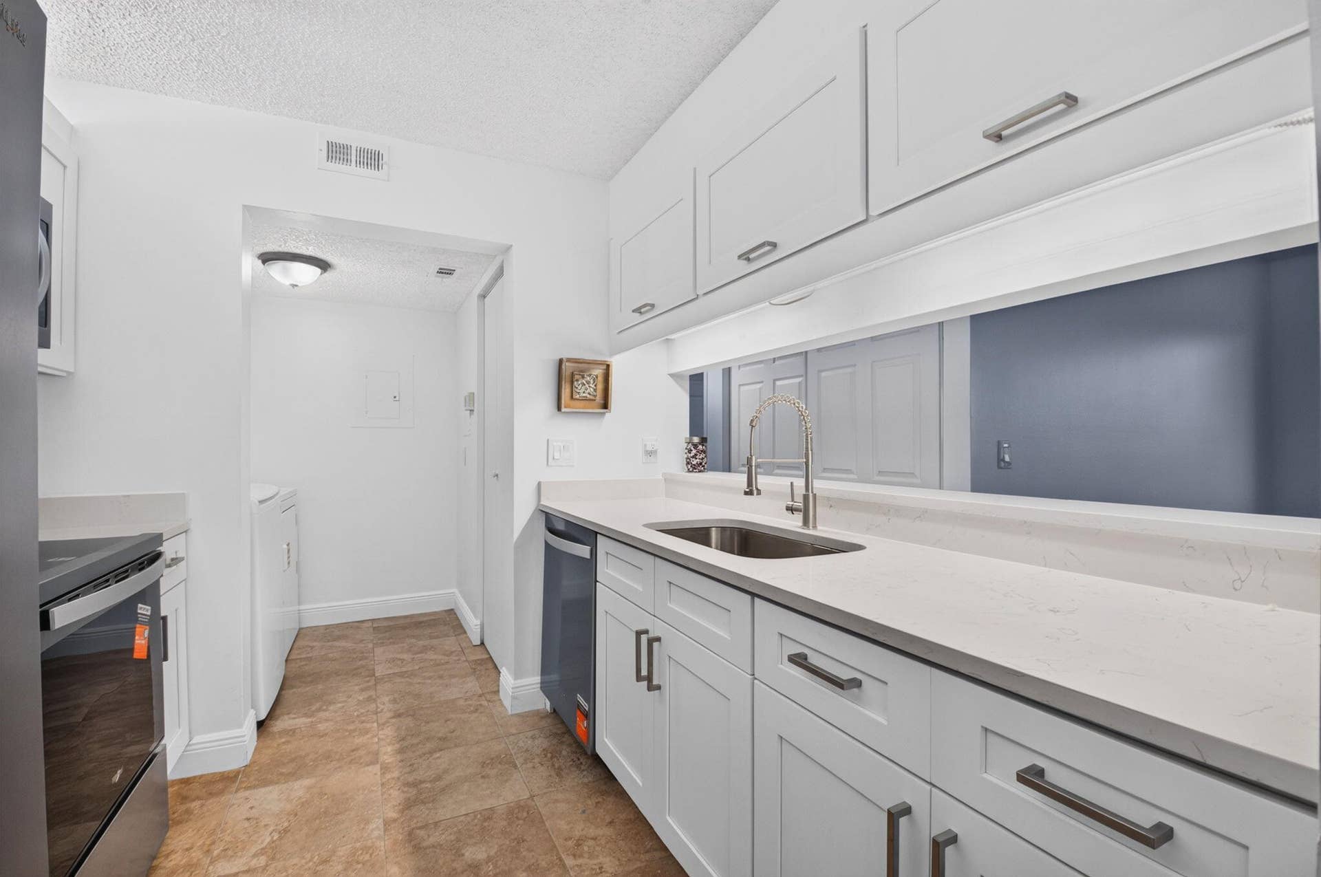Remodeled kitchen with shaker style cabinets and new stainless steel appliances.