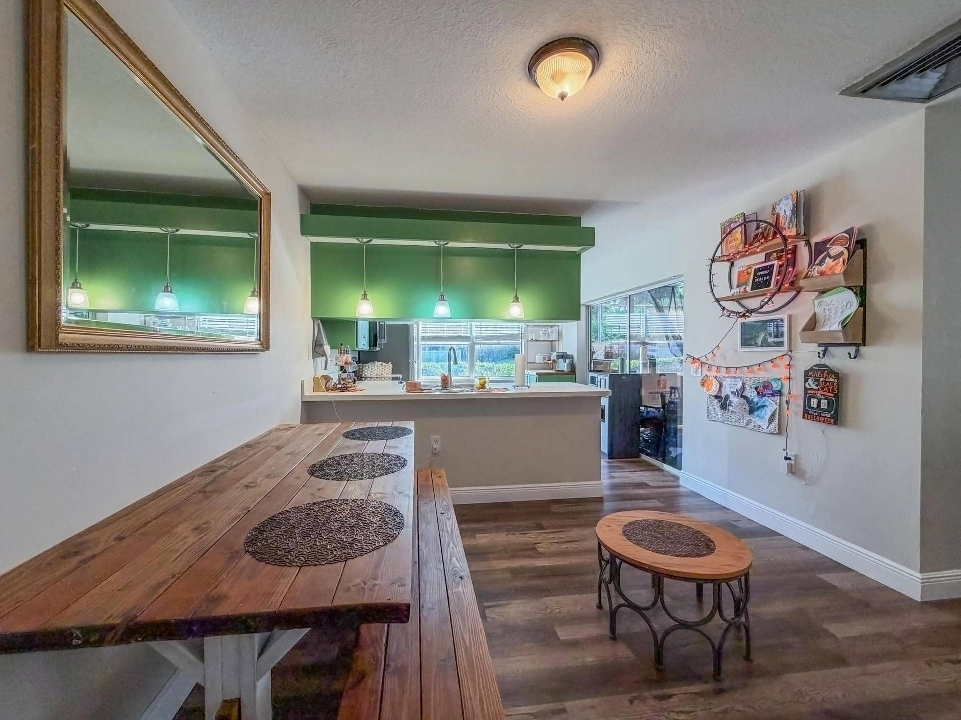 3233 SW SUNSET TRACE Circle, Palm City, FL 34990 Wood-finish flooring, kitchen peninsula with overhead pendant lighting, and wall-mounted mirror