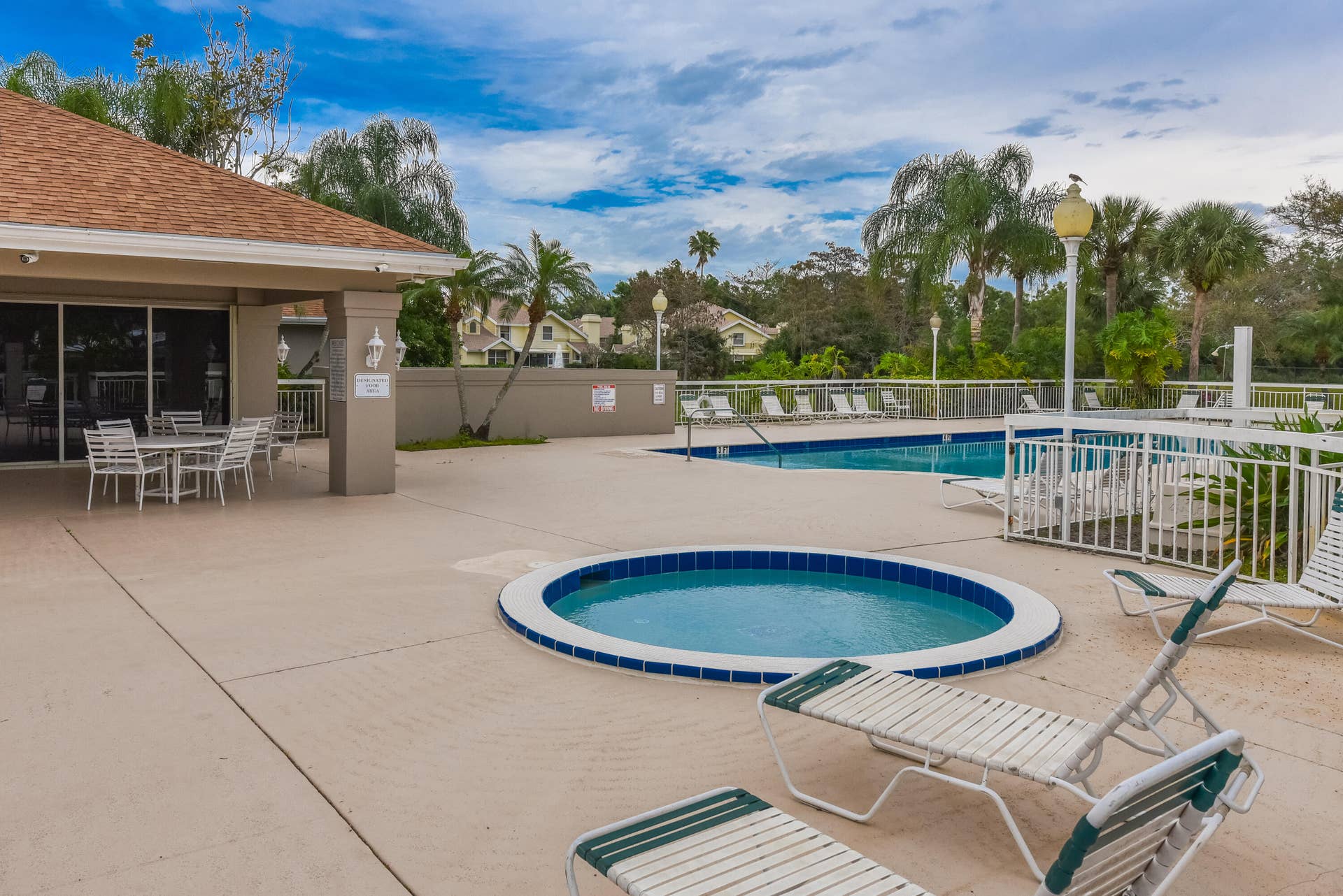 3233 SW SUNSET TRACE Circle, Palm City, FL 34990 Outdoor swimming pool and circular spa featuring concrete decking, perimeter fencing, and covered patio space