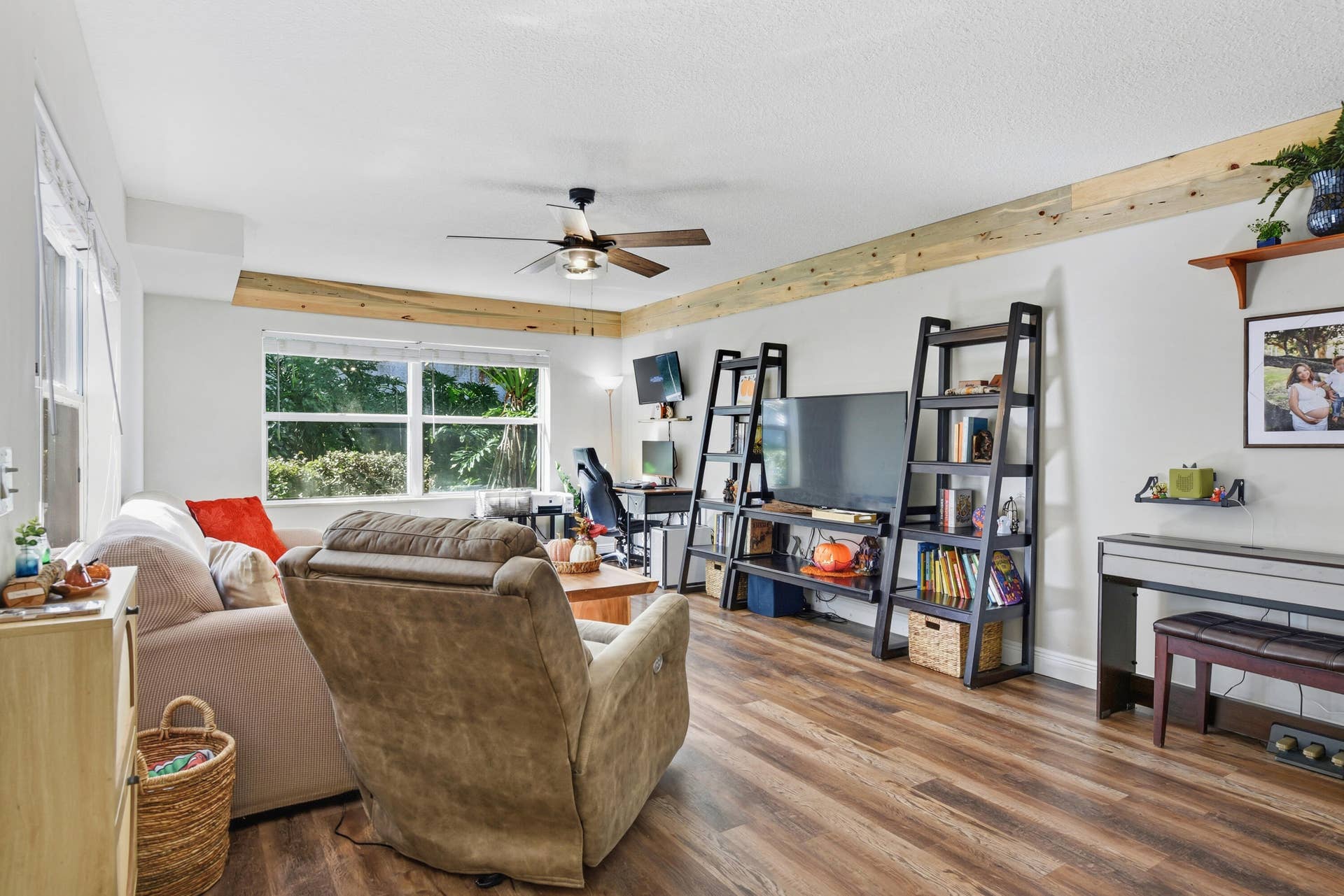 3233 SW SUNSET TRACE Circle, Palm City, FL 34990 Living area featuring wood-finish flooring, exposed natural wood ceiling beams, and a central ceiling fan