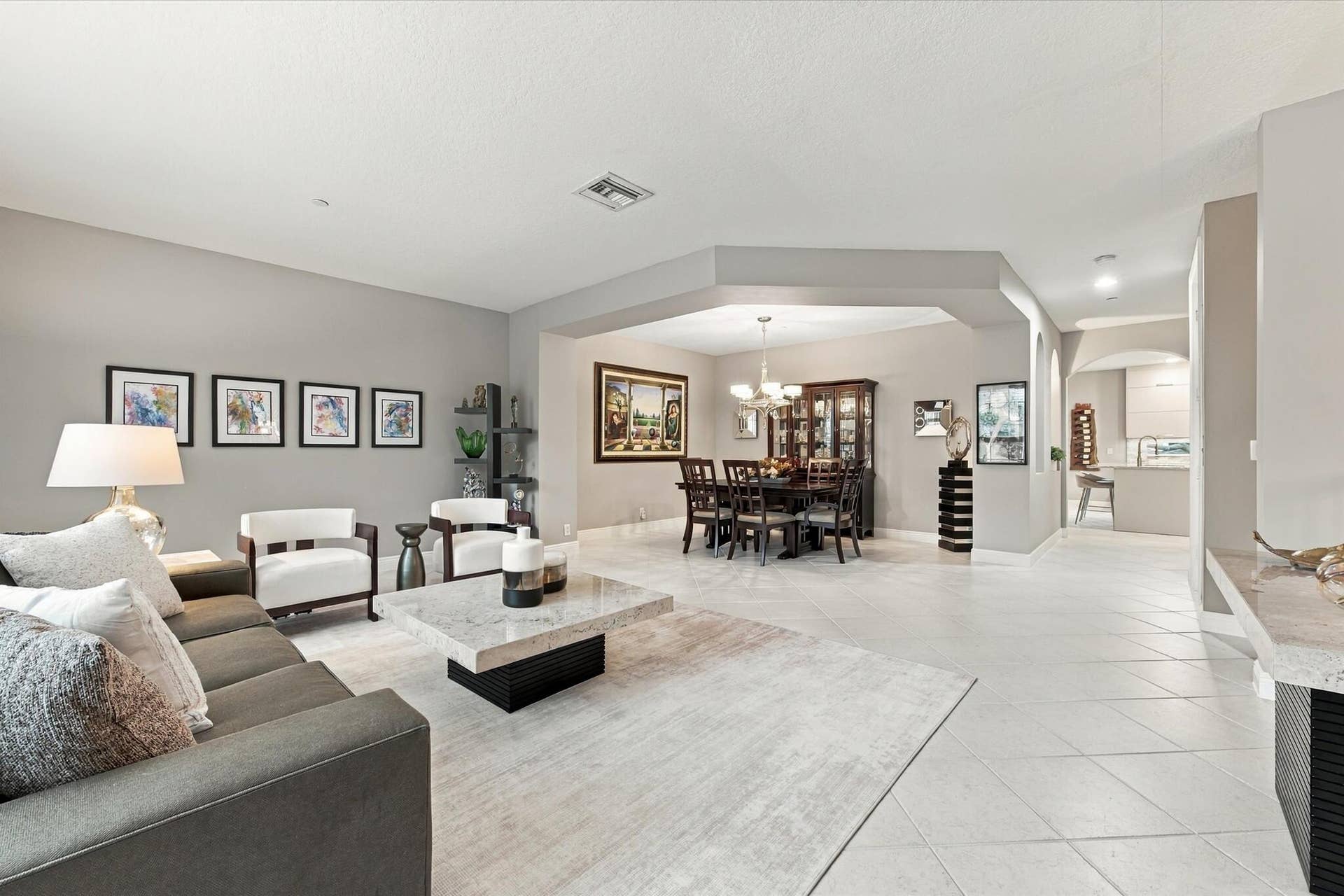 5545 NE Trieste Way, Boca Raton, FL 33487 Living area featuring neutral wall tones, large-format tile flooring, recessed lighting, and a distinct architectural recessed ceiling detail