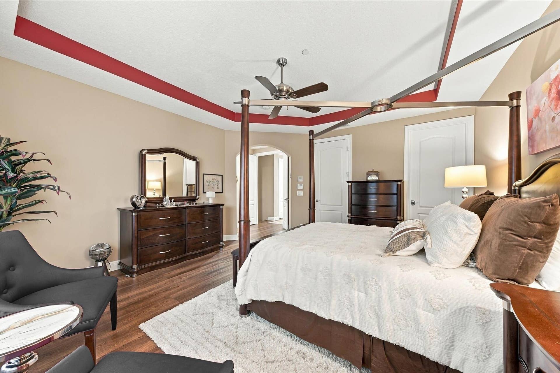 5545 NE Trieste Way, Boca Raton, FL 33487 Tray ceiling with accent molding, wood-finish flooring, and a central ceiling fan
