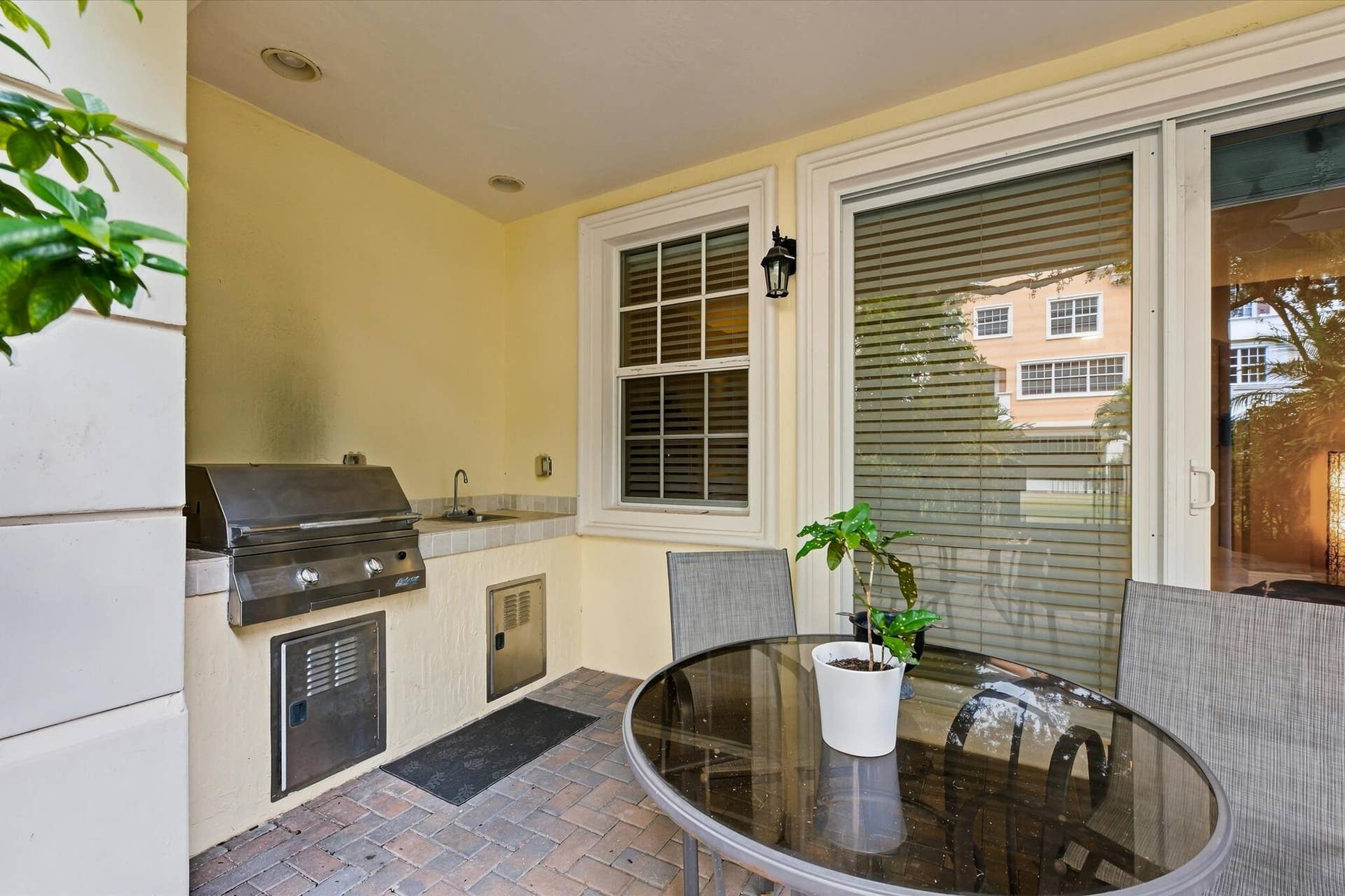 5545 NE Trieste Way, Boca Raton, FL 33487 Covered outdoor kitchen featuring brick paver flooring, stainless steel built-in grill, stone-finish countertop, integrated sink, and recessed lighting