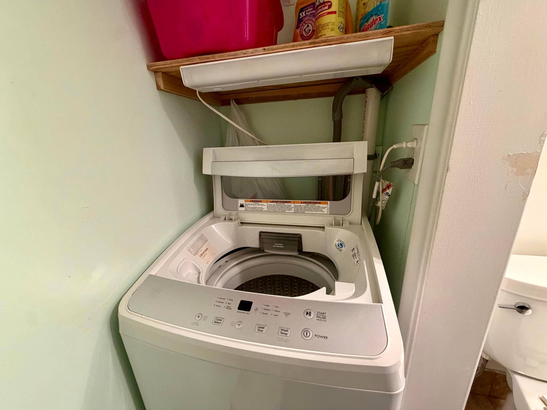 Top-loading washer with a digital control panel and built-in upper shelving