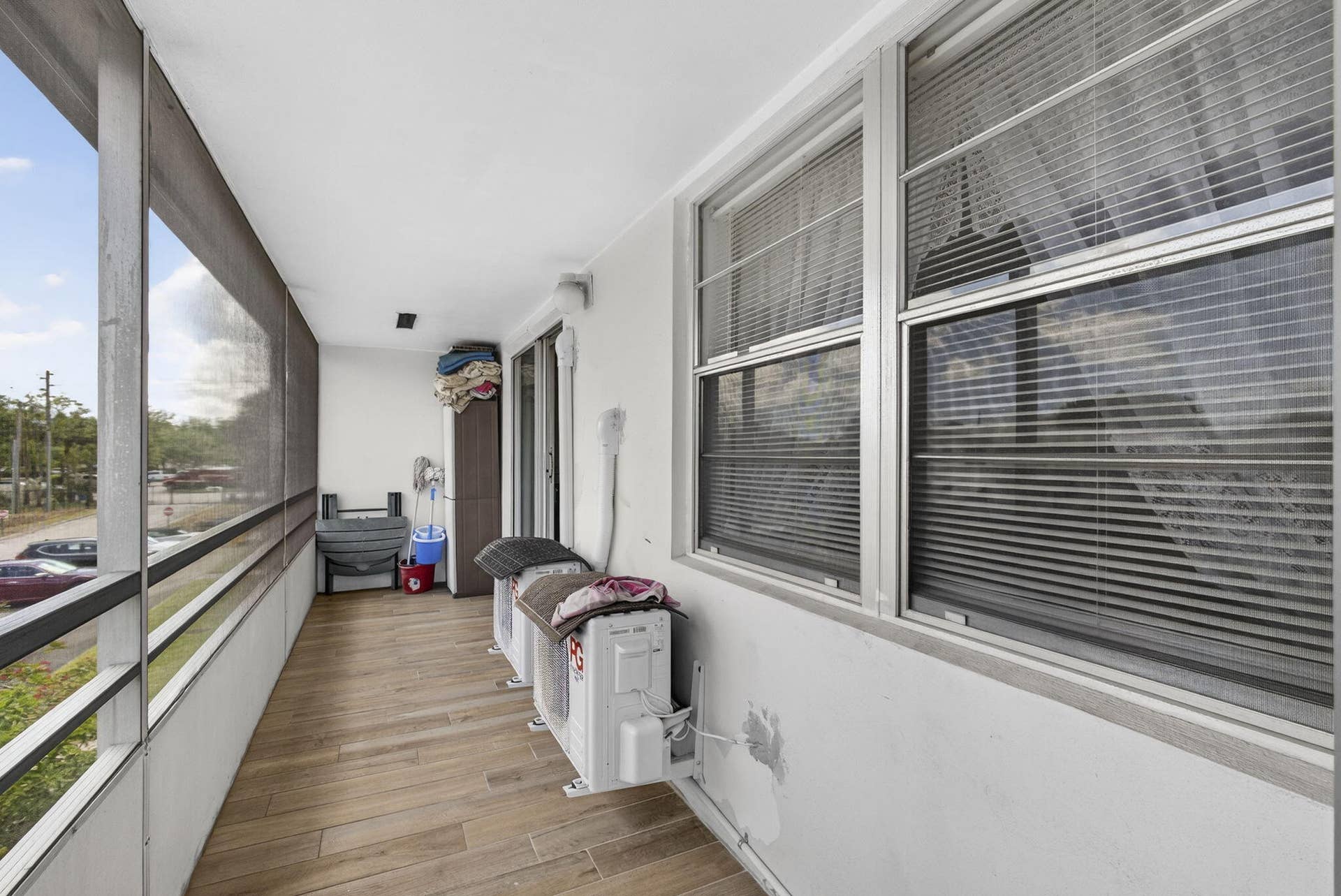 Enclosed porch featuring wood-finish flooring, metal-framed screens, and horizontal sliding windows