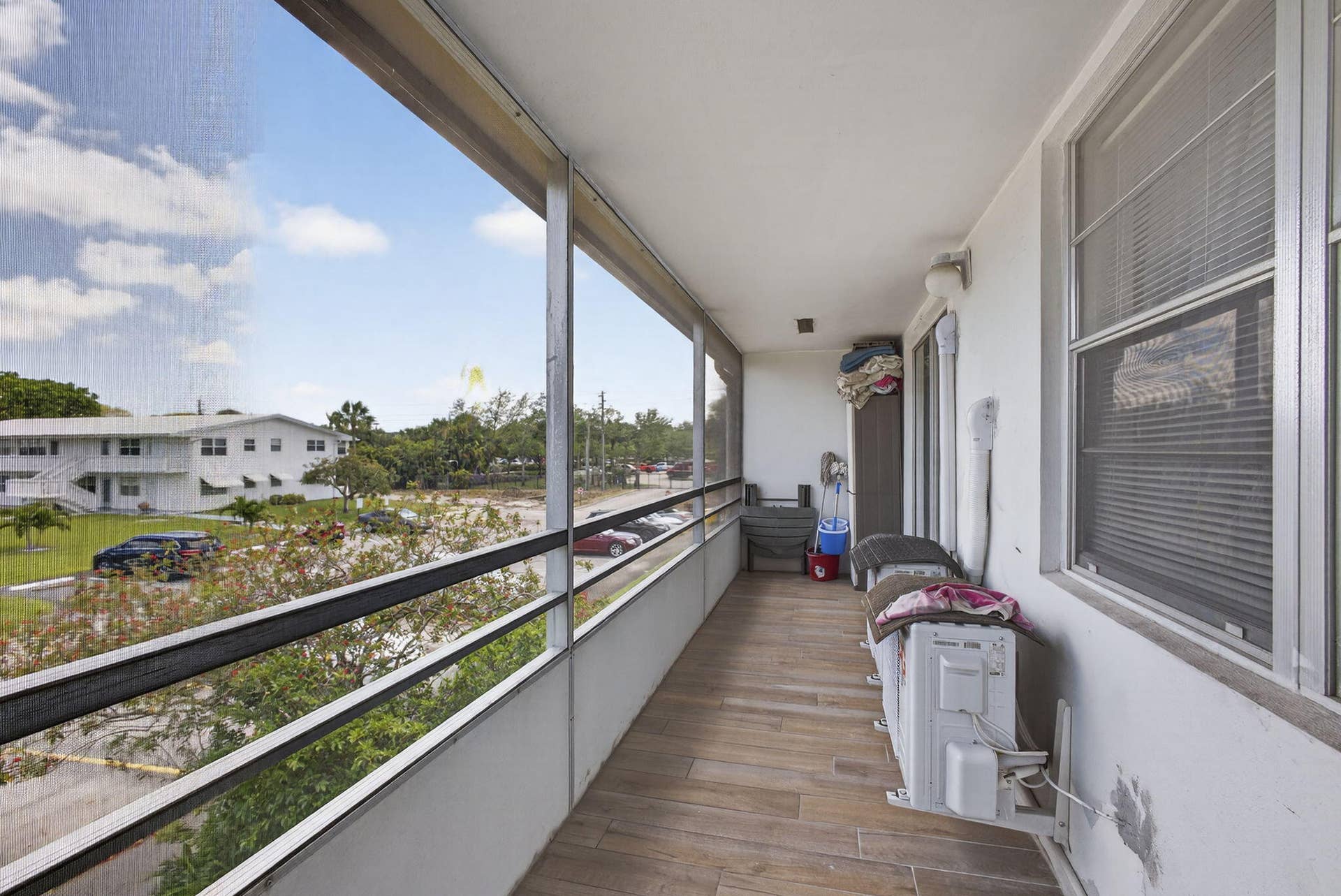 Screened balcony featuring wood-finish tile flooring and metal-framed screening