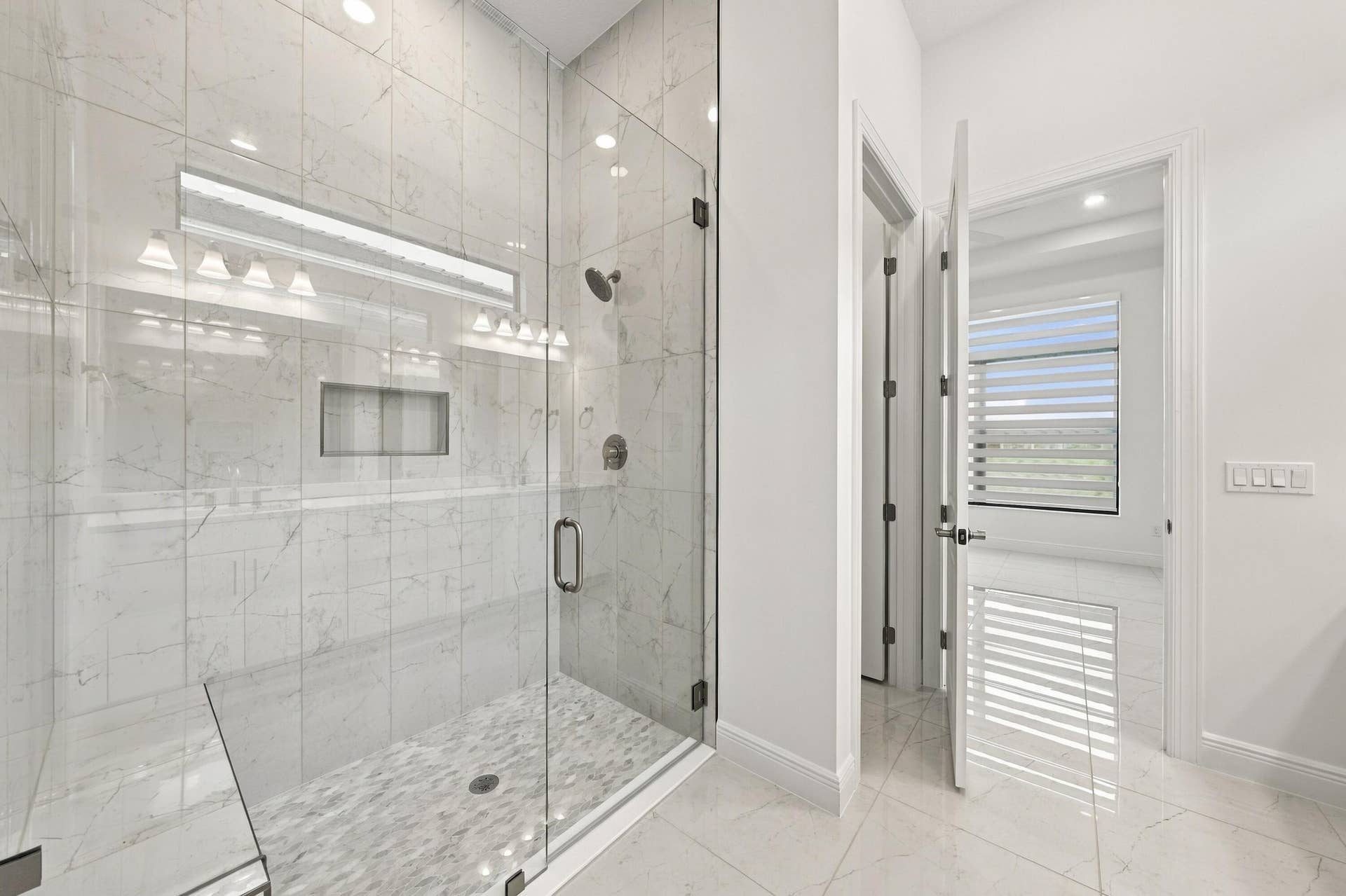 4931 Rivo Alto Circle, Westlake, FL 33470 Primary bathroom with upgraded 96inch glass frameless shower satin nickel finishes