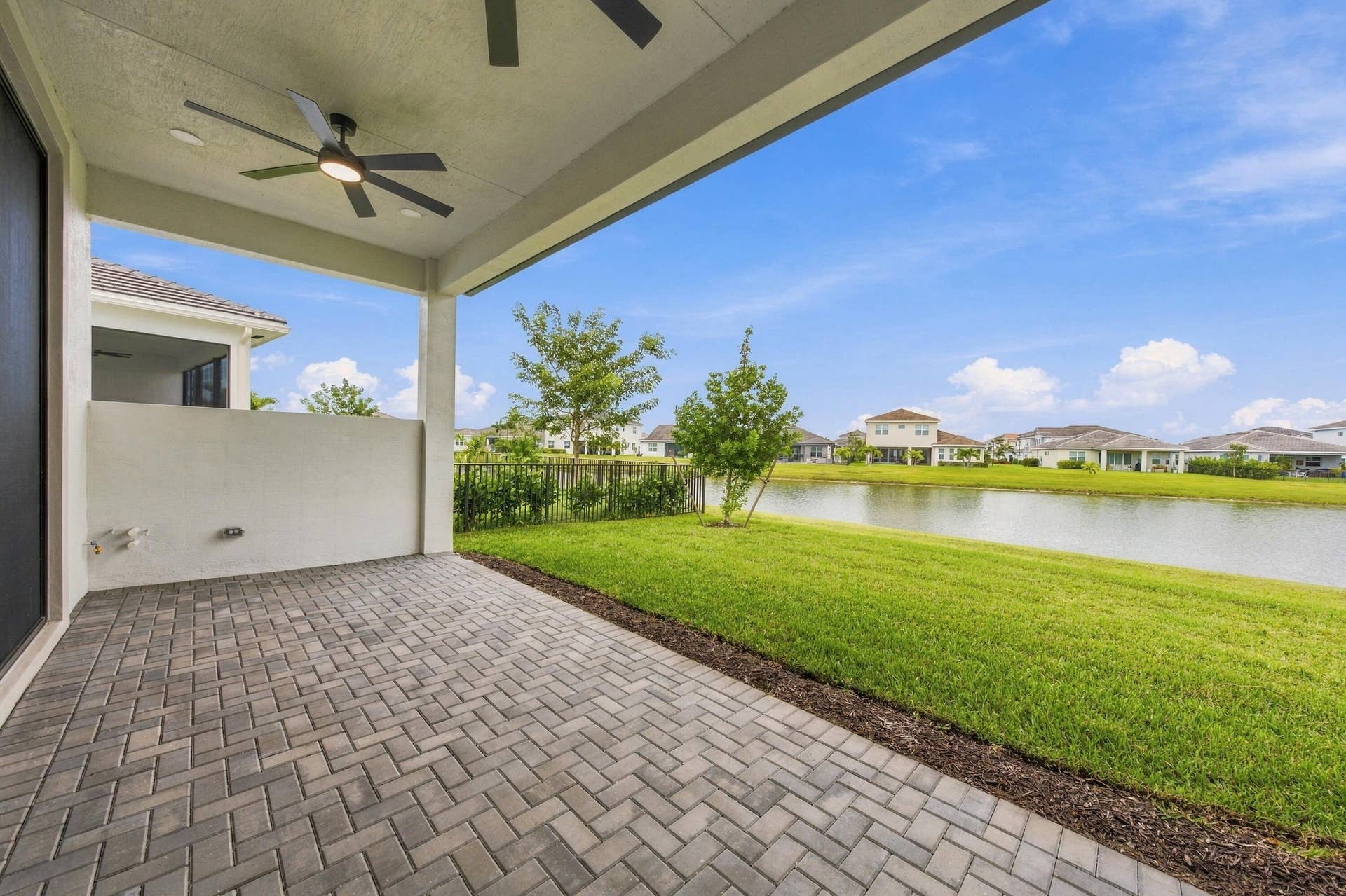 4931 Rivo Alto Circle, Westlake, FL 33470 Lakefront covered lanai with ceiling fans, 5ft privacy wall and stub out gas/water lines for future summer kitchen