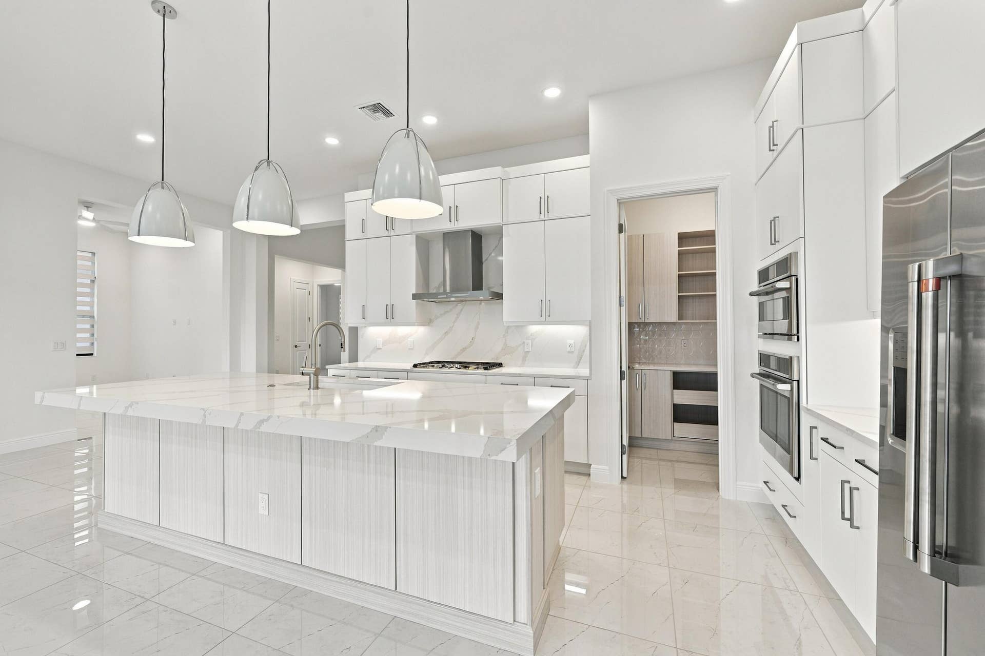 4931 Rivo Alto Circle, Westlake, FL 33470 Oversized island with 3 inch upgraded quartz countertop, island pendant lights with GE cafe appliaces