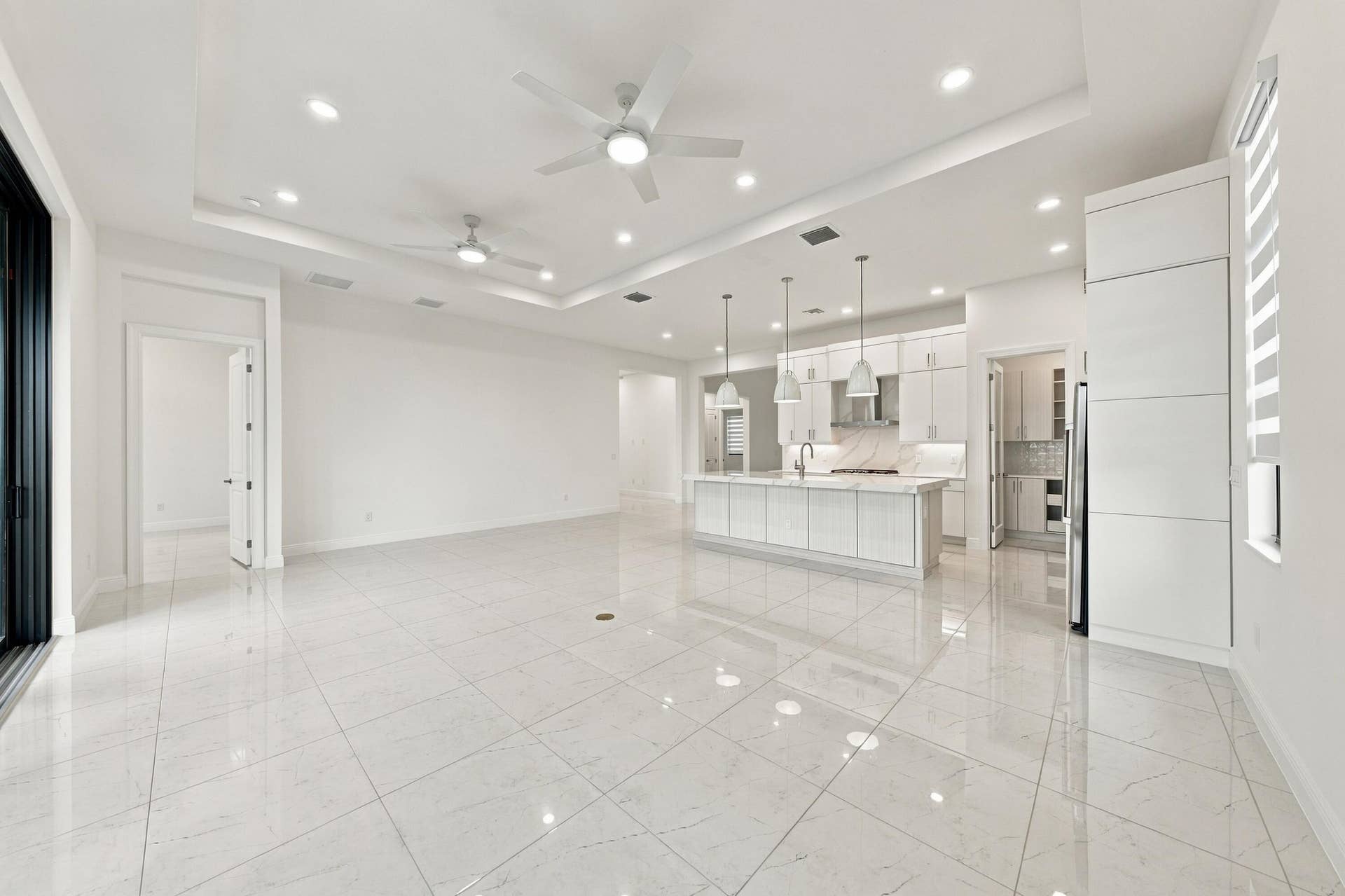4931 Rivo Alto Circle, Westlake, FL 33470 Dining area, great room and kitchen with raised tv outlet and level 5 upgraded tile floors throughout the home