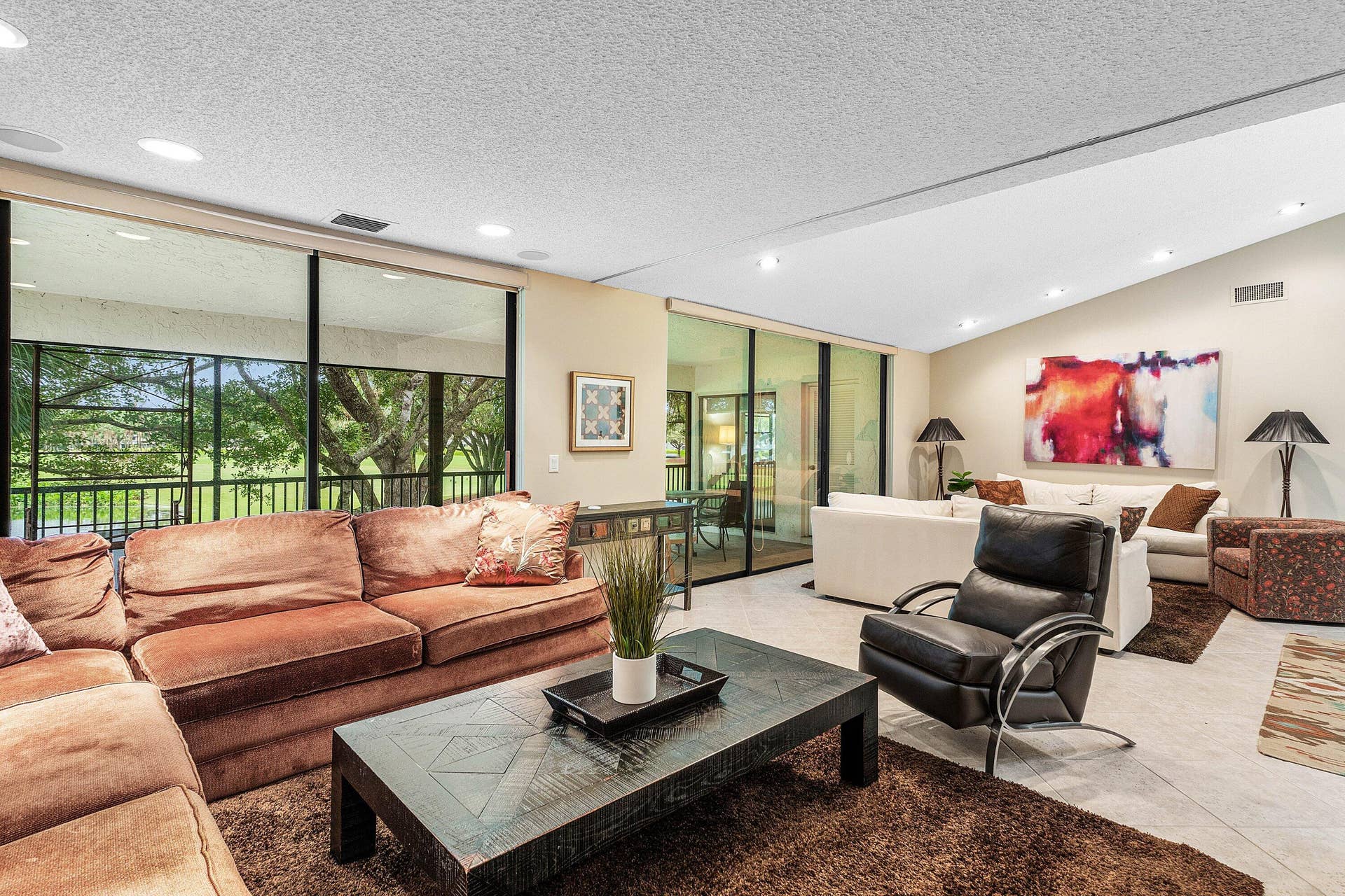 53 EASTGATE Drive, #B, Boynton Beach, FL 33436 Vaulted ceilings with recessed lighting, expansive floor-to-ceiling glass doors, and light-toned tile flooring