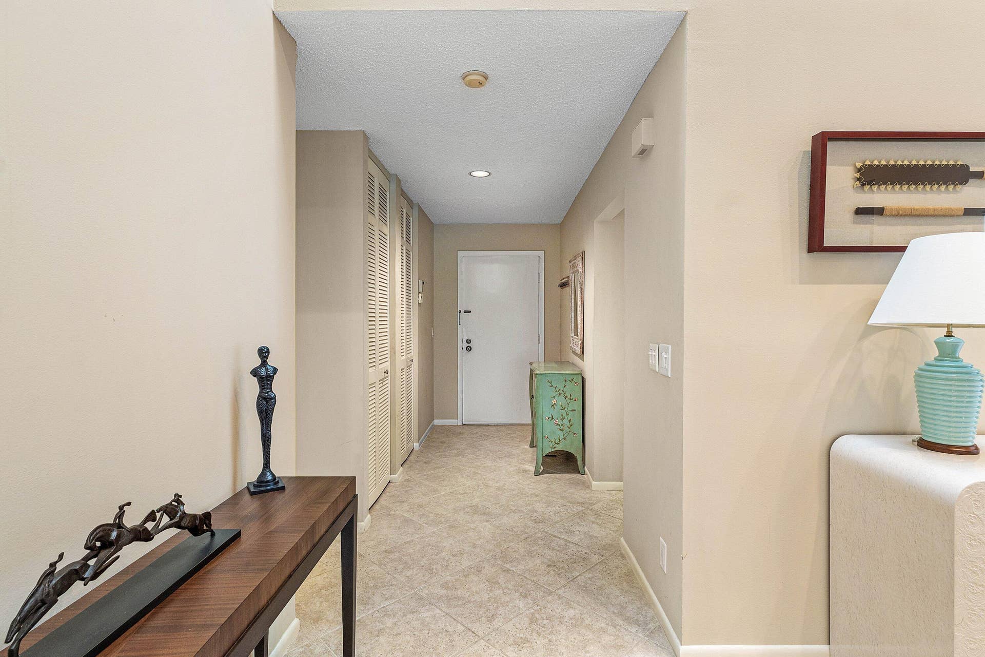 53 EASTGATE Drive, #B, Boynton Beach, FL 33436 Entryway featuring neutral tile flooring, built-in floor-to-ceiling louvered cabinetry, and recessed lighting