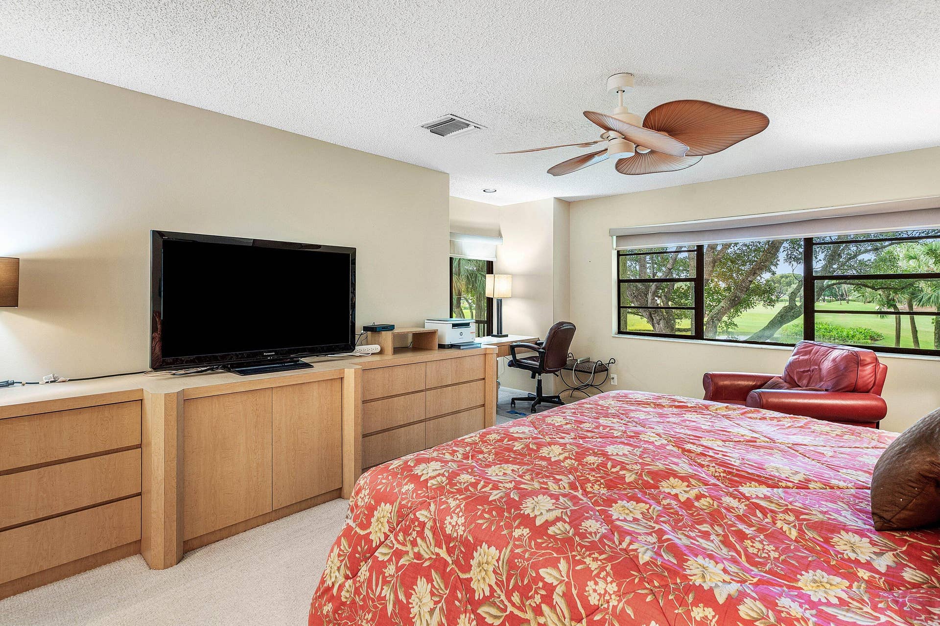 53 EASTGATE Drive, #B, Boynton Beach, FL 33436 Built-in light-toned cabinetry, multi-blade ceiling fan, and large windows with landscape scenery