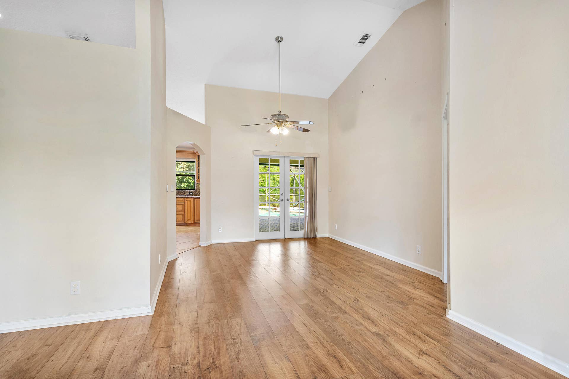 13677 Citrus Grove Boulevard, West Palm Beach, FL 33412 Vaulted ceilings featuring a central ceiling fan, wood-finish flooring, and glass-paned French doors
