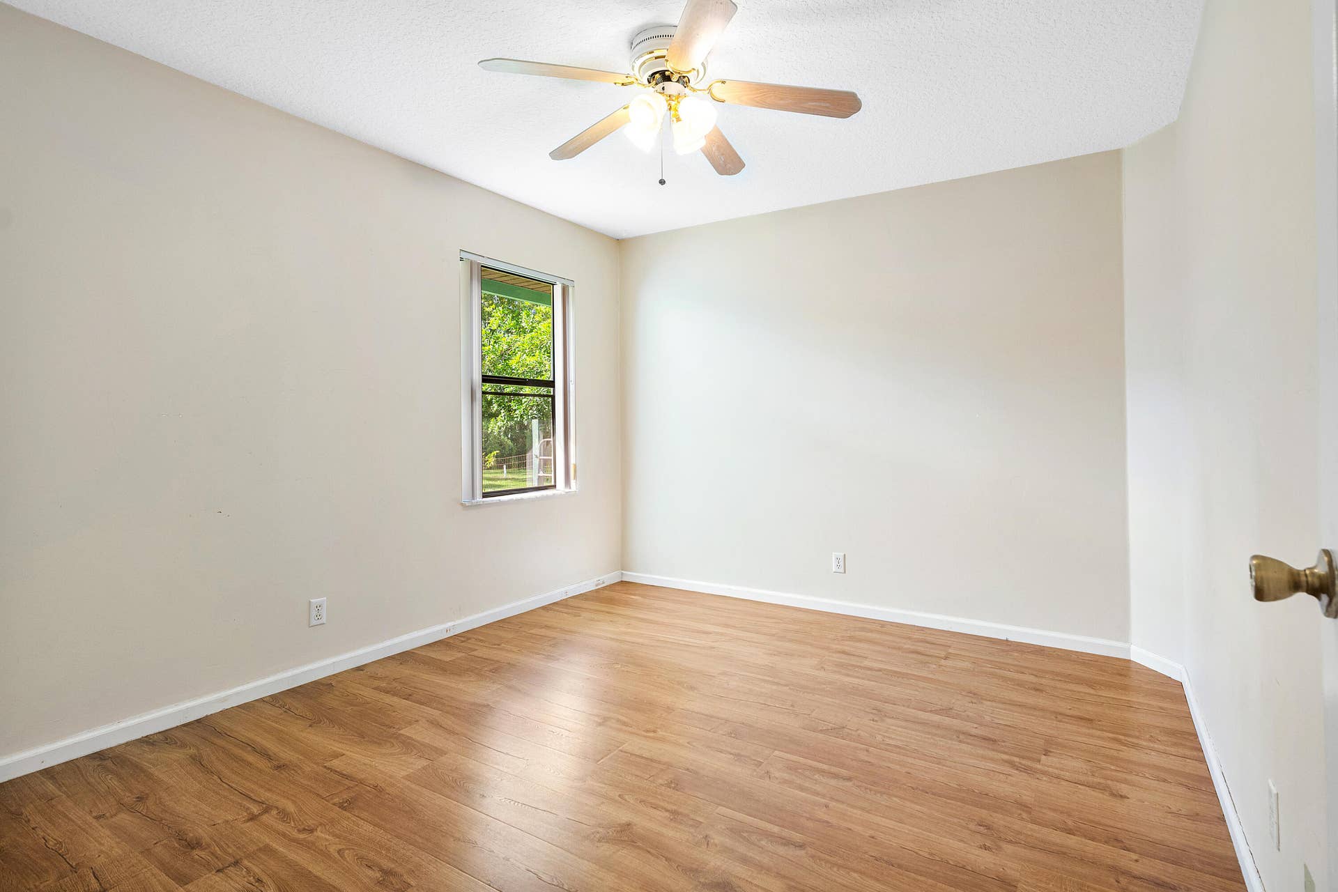 13677 Citrus Grove Boulevard, West Palm Beach, FL 33412 Bedroom four featuring wood-finish flooring, a neutral wall palette, single-pane window, and a ceiling fan with integrated lighting