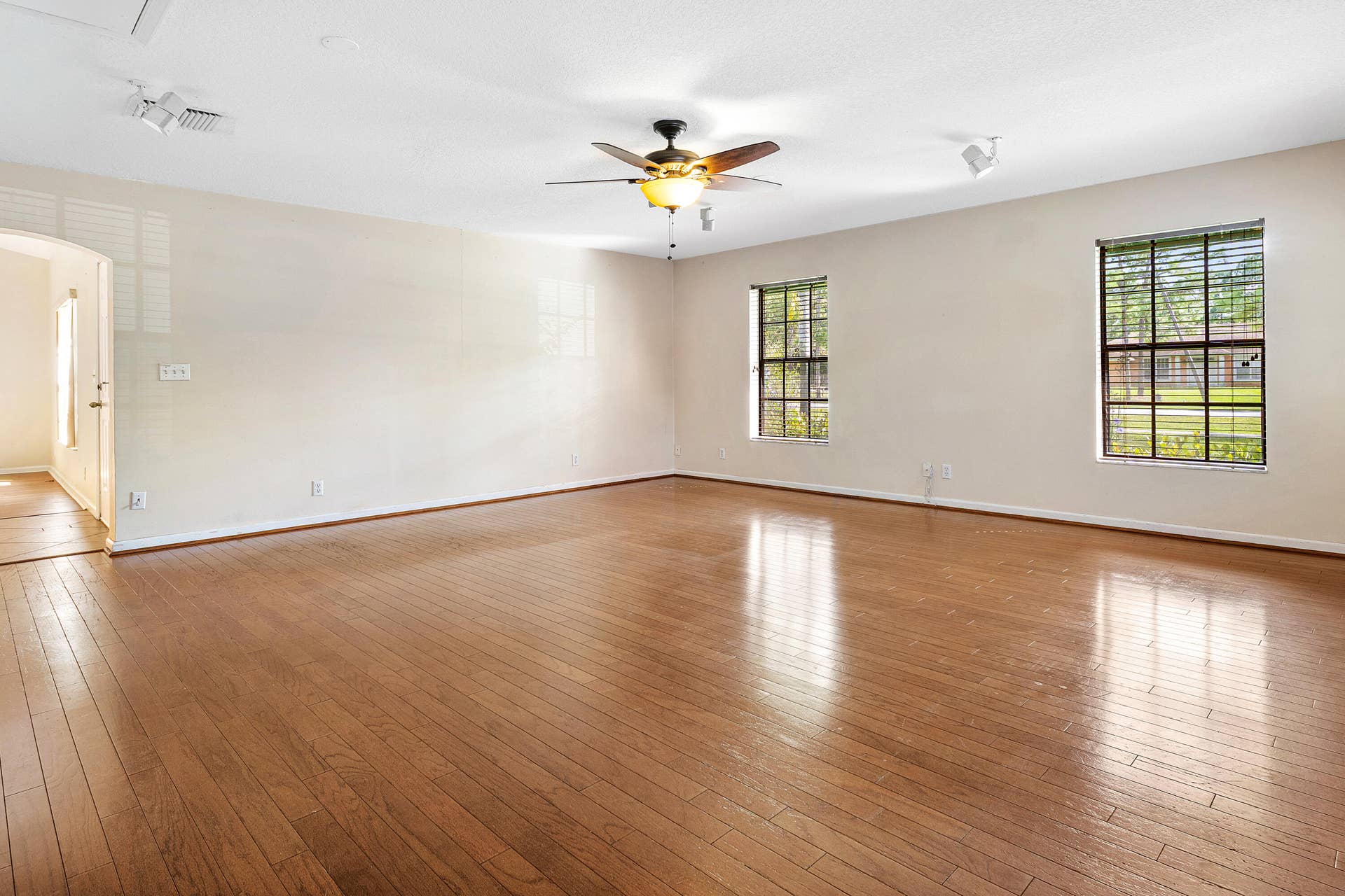 13677 Citrus Grove Boulevard, West Palm Beach, FL 33412 Wood-finish flooring throughout, dual windows with grid muntins, a ceiling fan with integrated lighting, and recessed track lighting