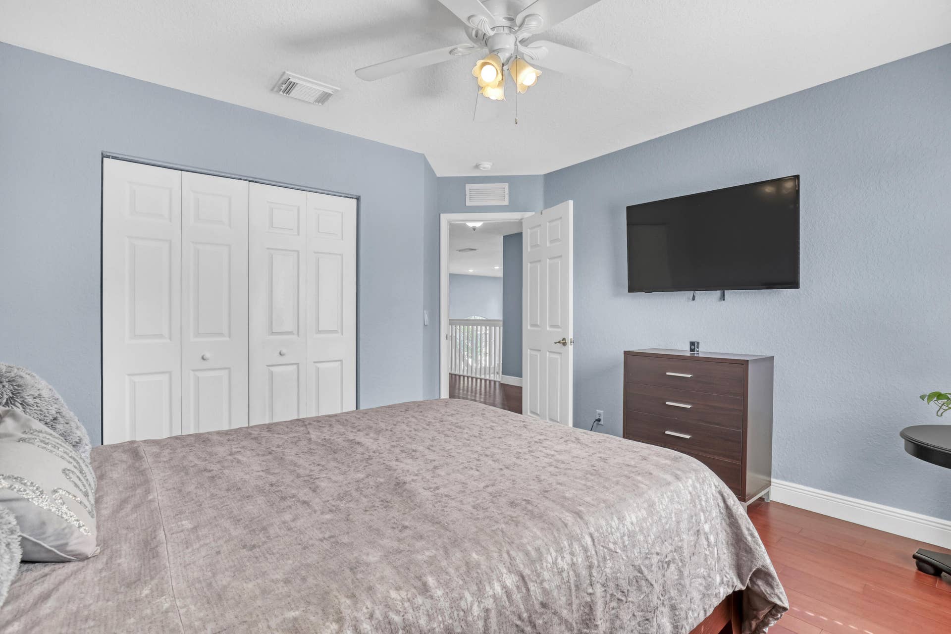 762 GAZETTA Way, West Palm Beach, FL 33413 Room featuring wood-finish flooring, white bi-fold closet doors, a multi-bulb ceiling fan, and six-panel interior doors