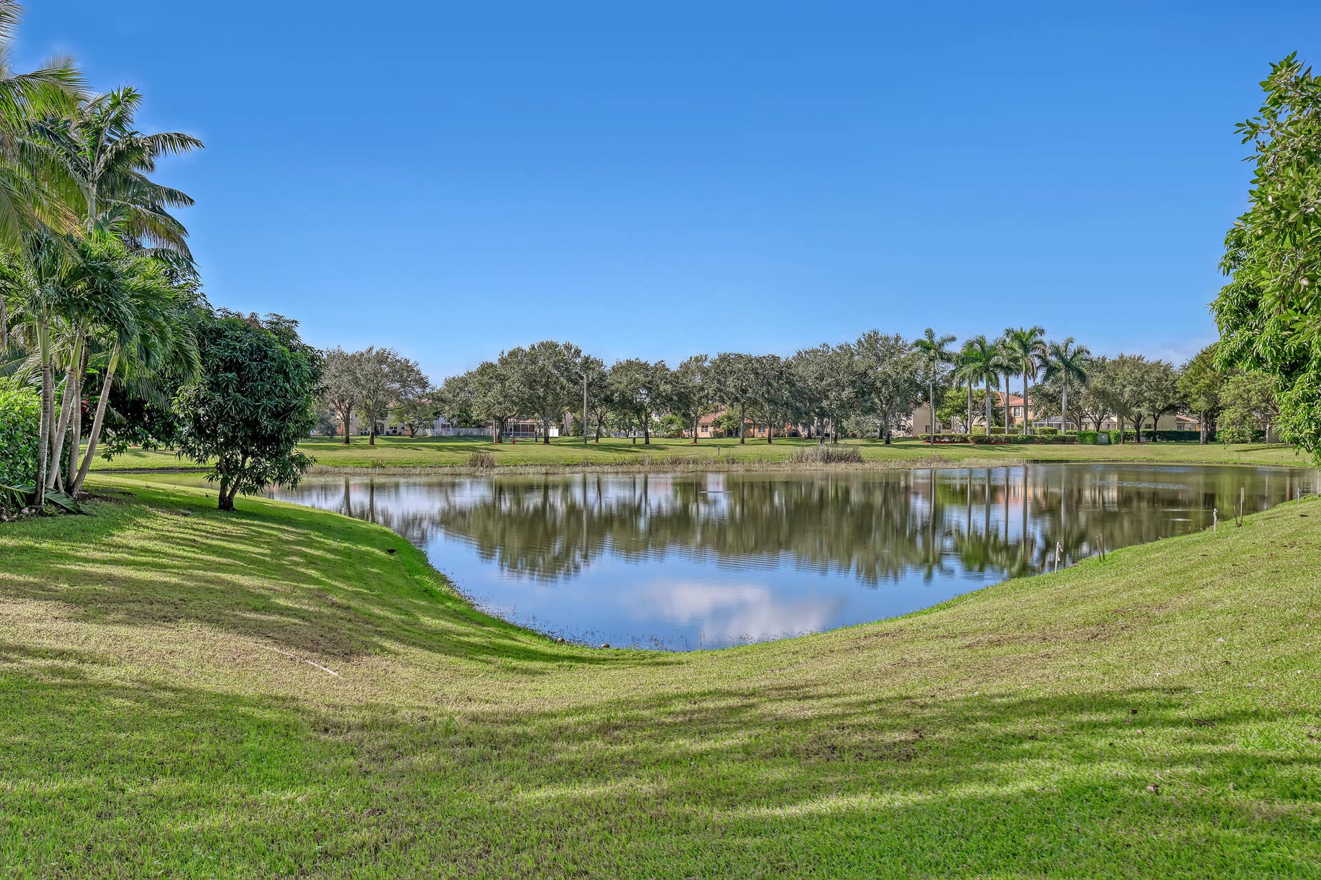 762 GAZETTA Way, West Palm Beach, FL 33413 Waterfront lot featuring a large lake, expansive grassy grounds, and mature palm and shade trees
